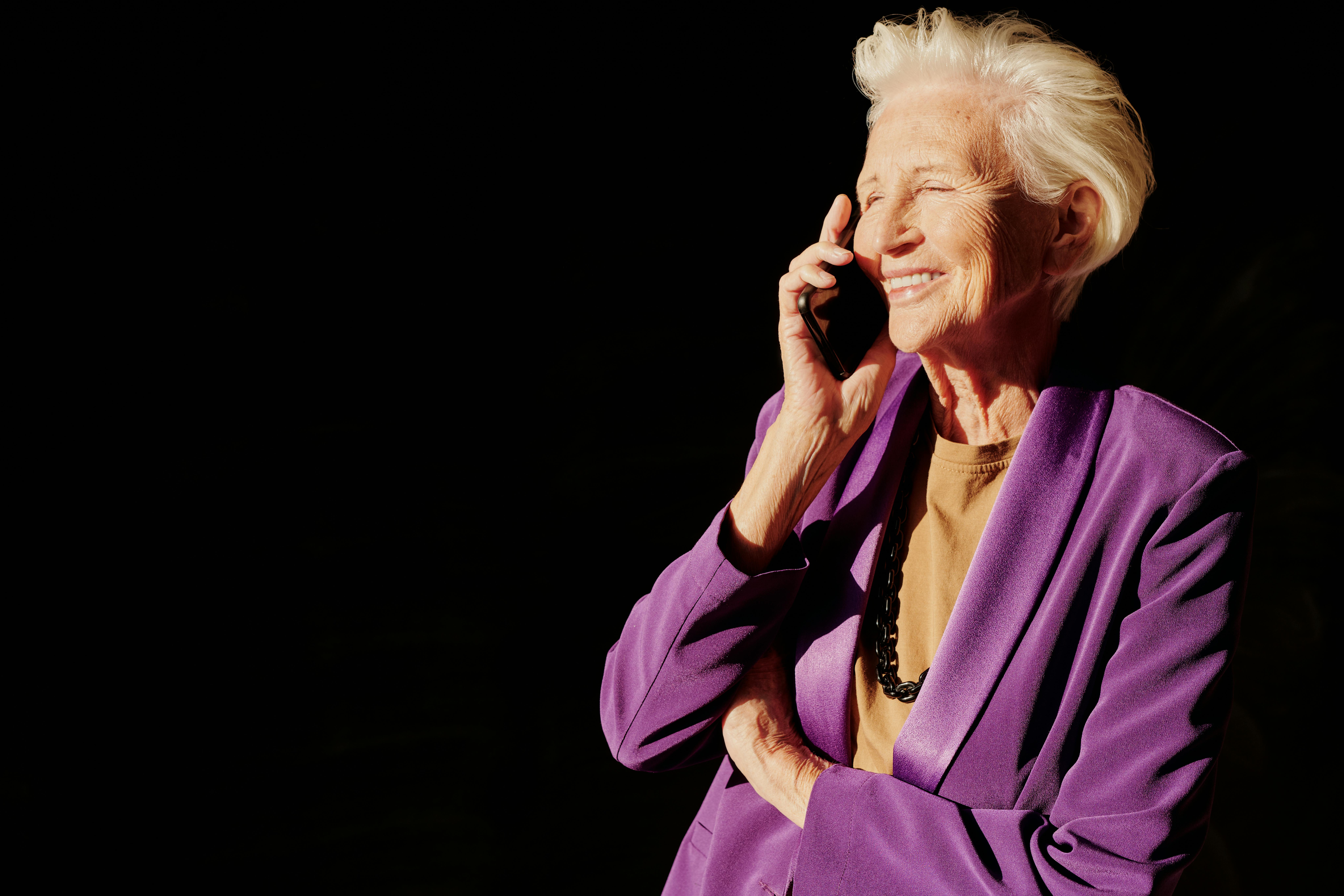 A smiling senior woman on a phone call | Source: Pexels