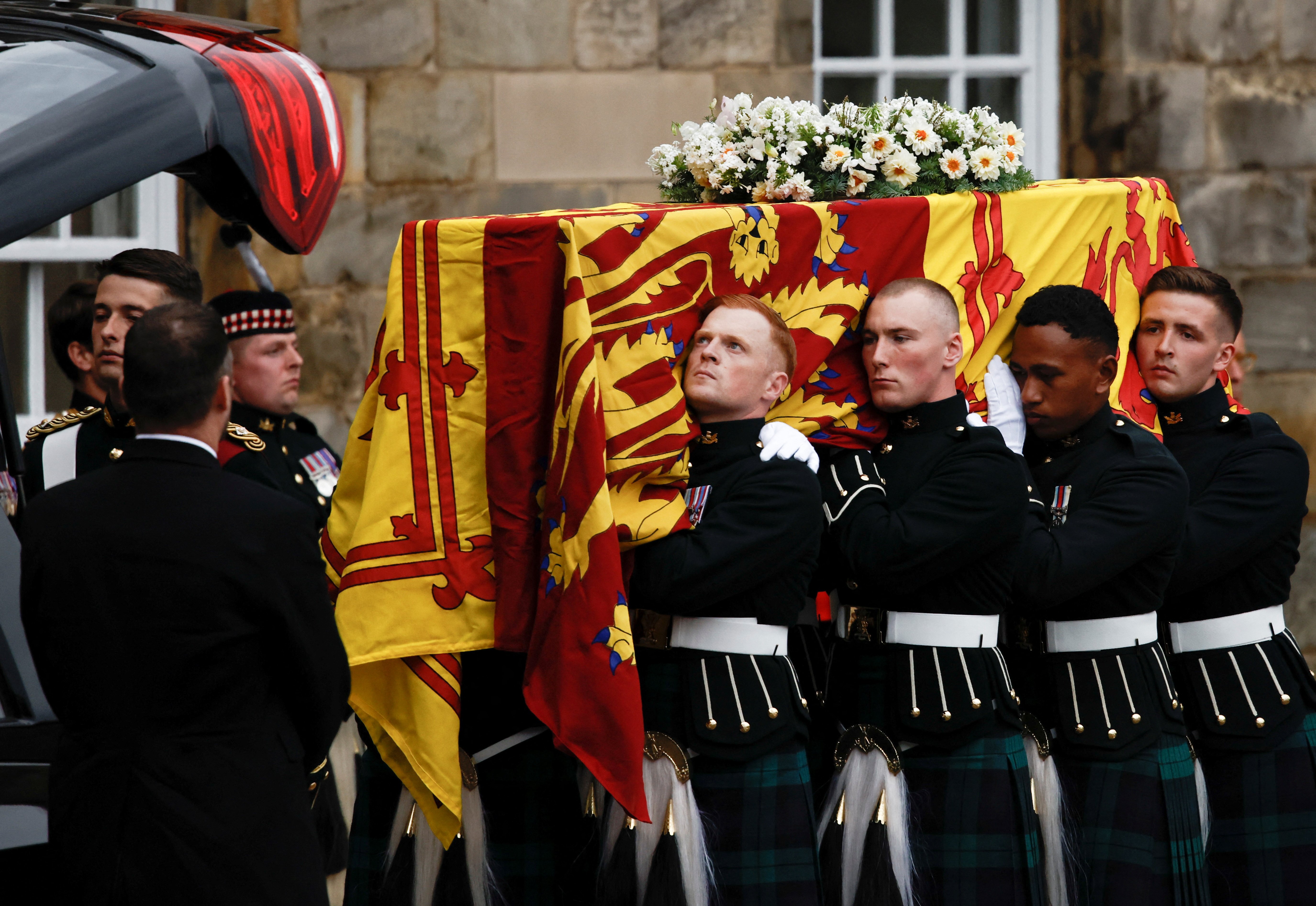 Pallbearers carry the coffin of Britain's Queen Elizabeth II as the hearse arrives at the Palace of Holyroodhouse on September 11, 2022, in Edinburgh, United Kingdom. | Source: Getty Images