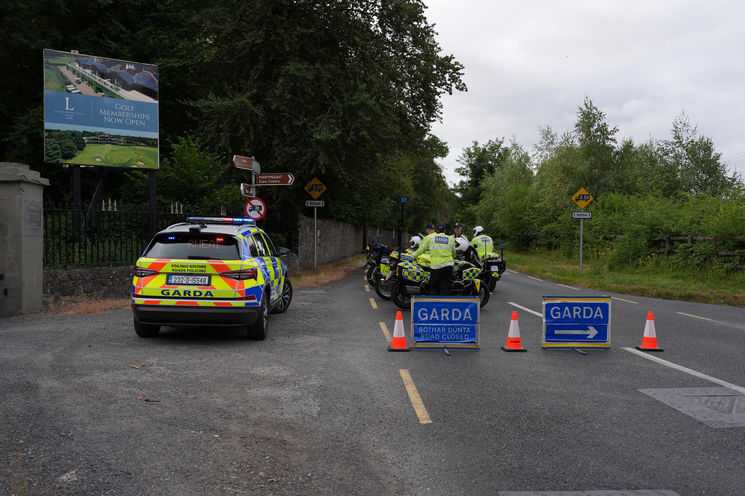 A full blockade of Gardaí, including multiple motorcycle units and road closure barriers, seals off the R109 at Lucan. The extensive police presence ensures the crash site is strictly preserved for forensic collision investigators. | Source: Getty Images.