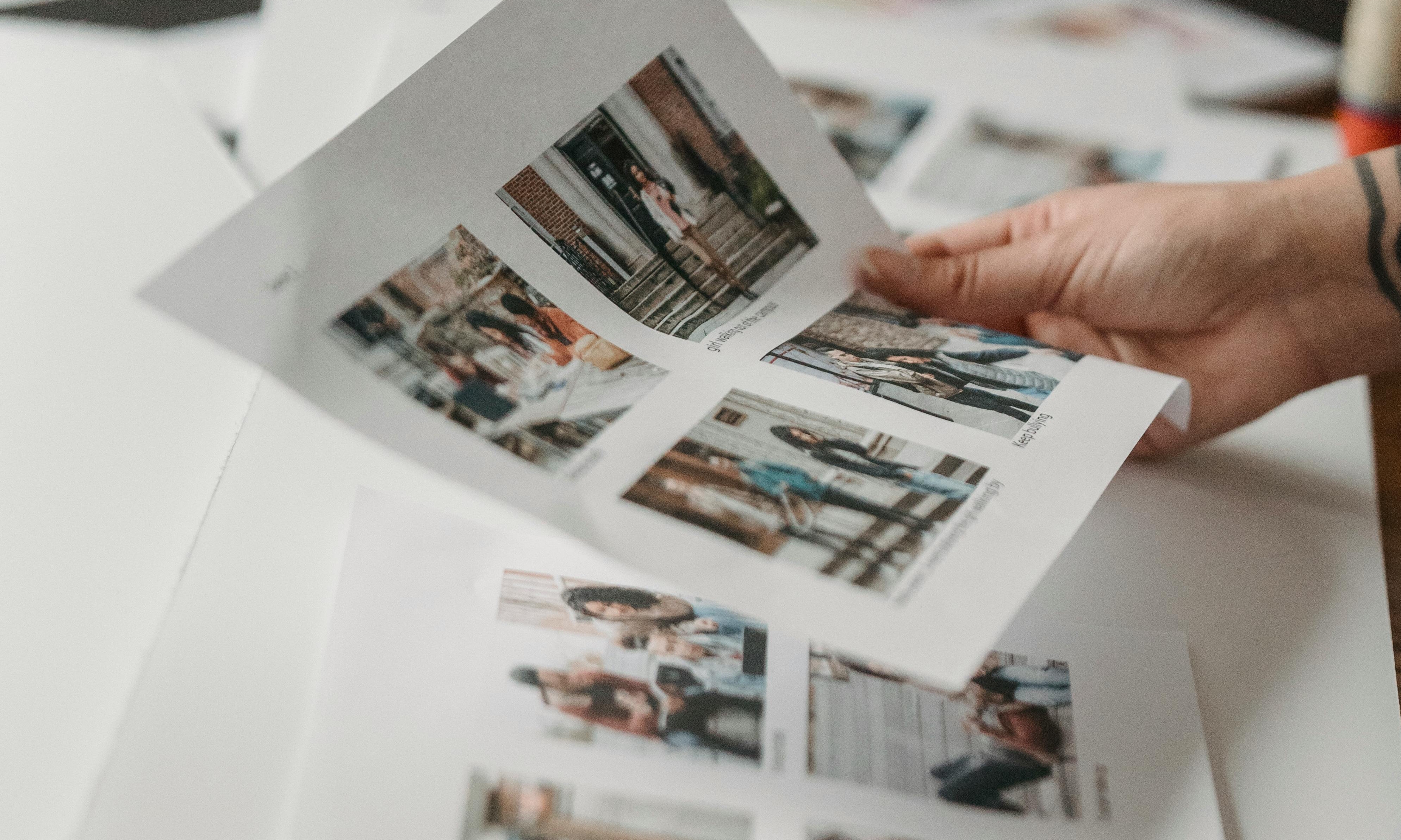A hand holding a page of printed photos | Source: Pexels