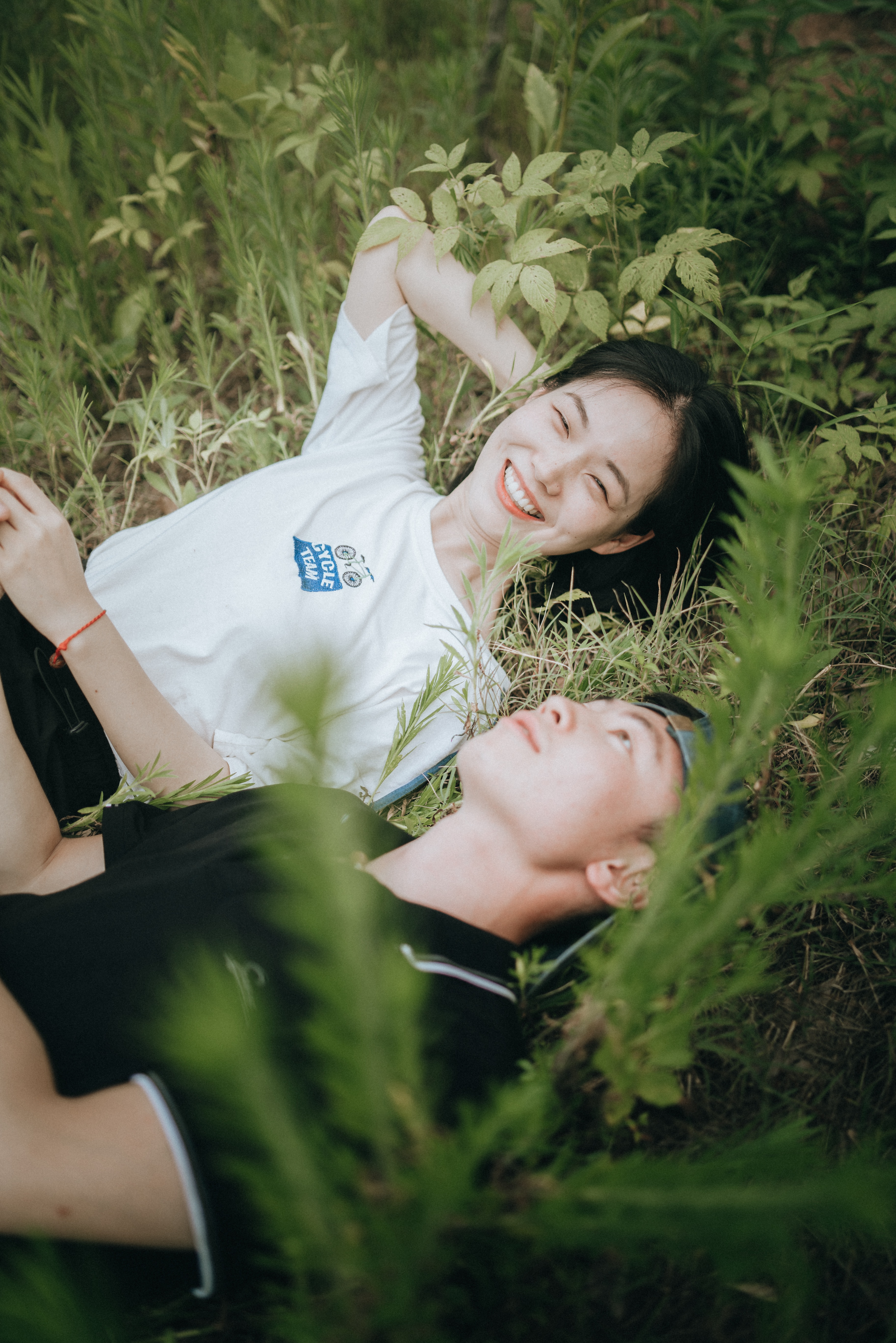 A photo of a man and woman laying on grass | Source: Unsplash