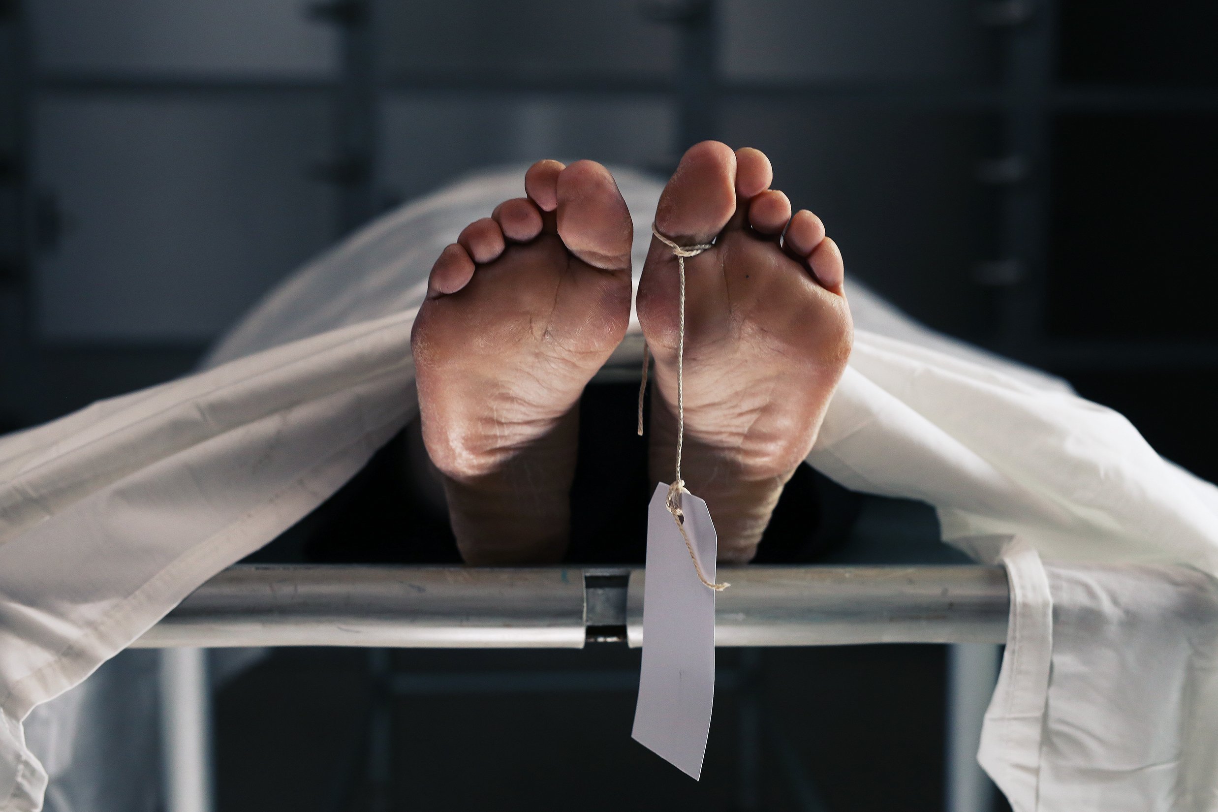 Body on a morgue table with a toe tag. | Source: Shutterstock