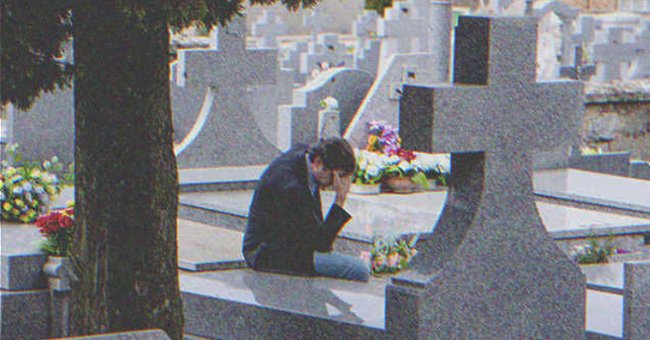 Hombre sentado frente a una tumba en un cementerio. | Foto: Shutterstock