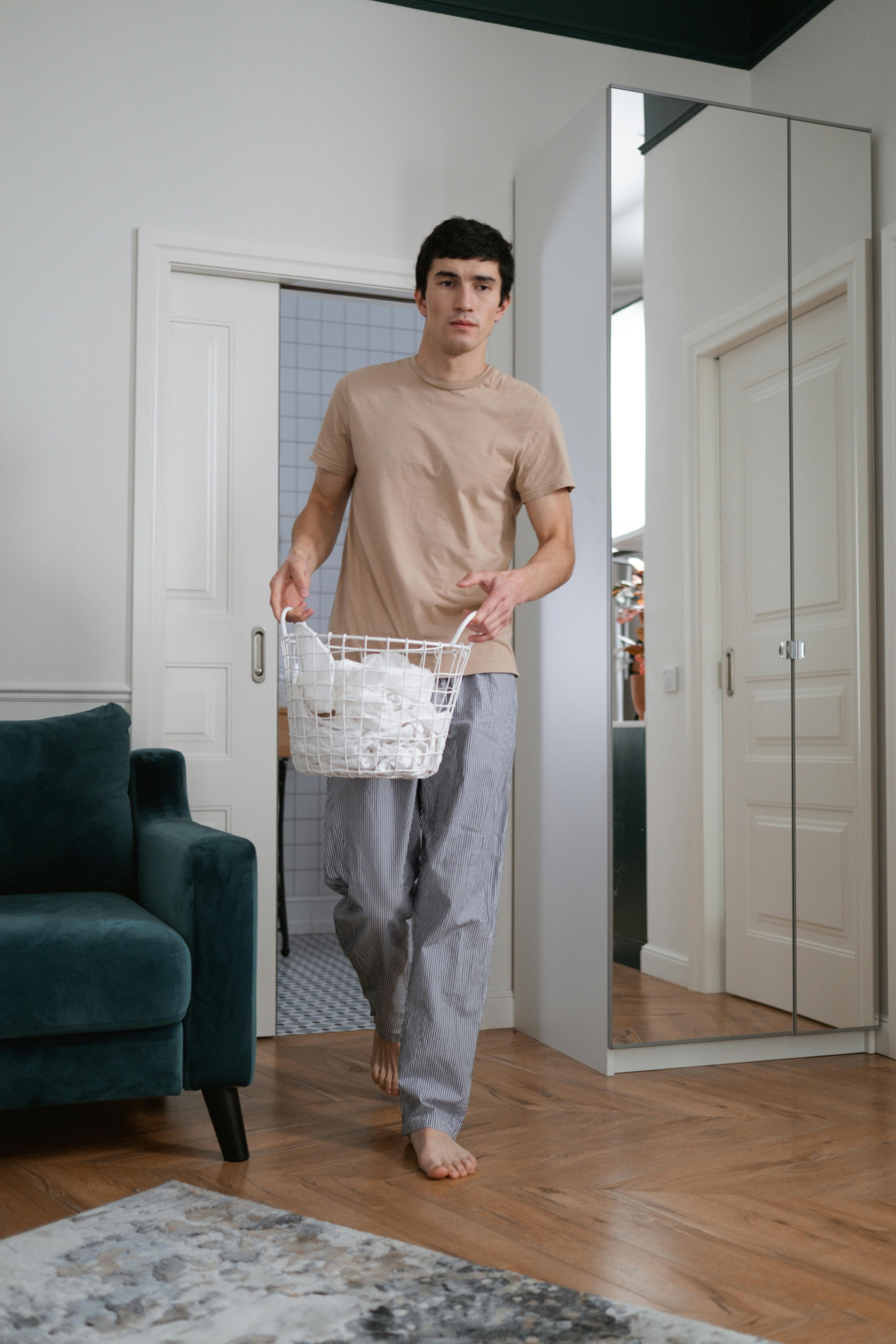 A man holding a laundry basket with clothes | Source: Pexels