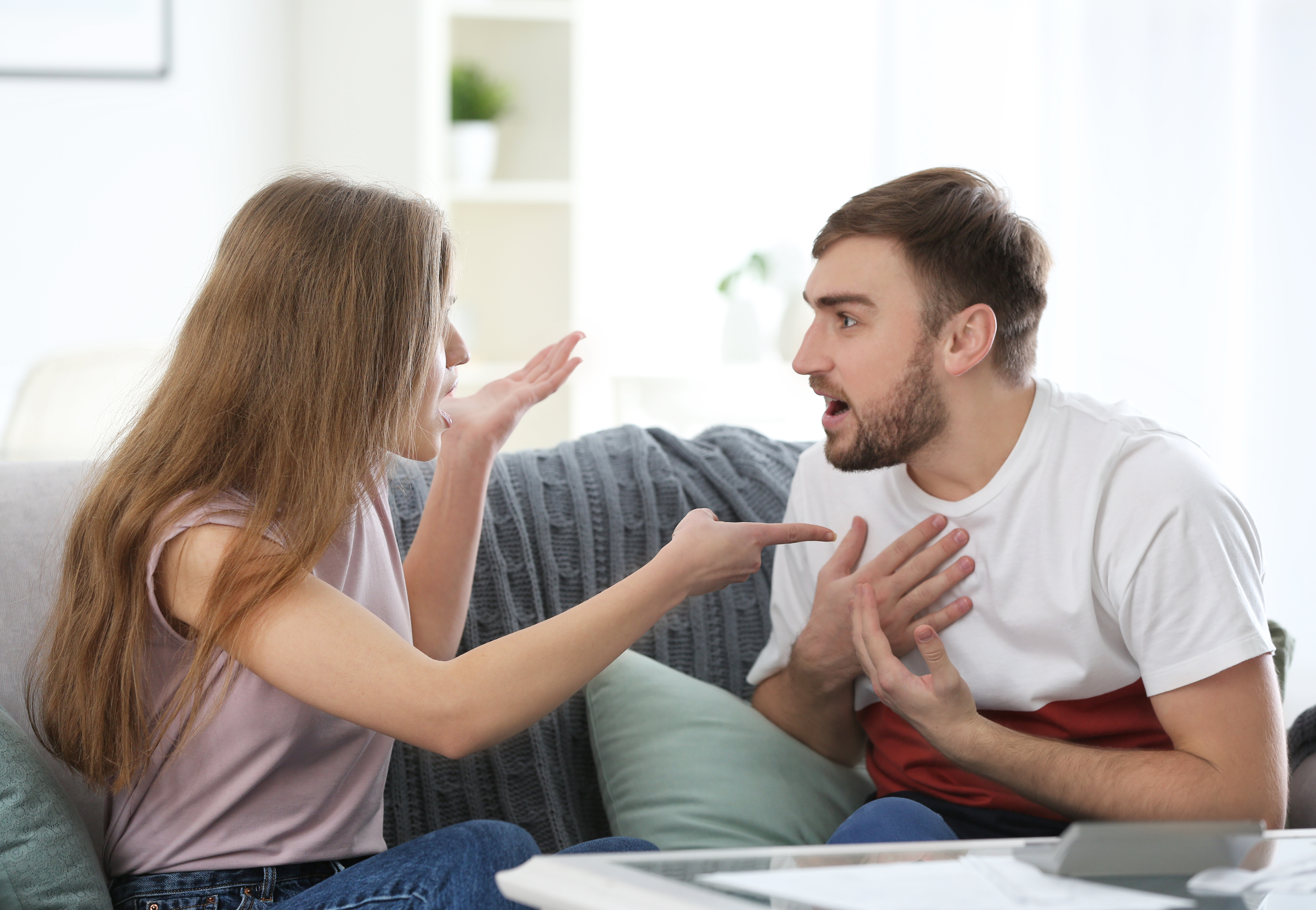 Um casal discutindo em um sofá | Fonte: Shutterstock