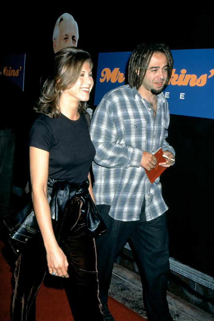 Jennifer Aniston attended the "Mr. Jenkins' Soiree" at the Ace Gallery in Los Angeles with musician Adam Duritz in September 1995. She wore a fitted black T-shirt tucked into a black satin skirt, with her hair styled in loose curls.