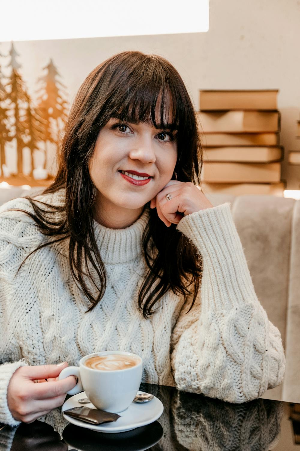 A woman drinking coffee in a cafe | Source: Pexels