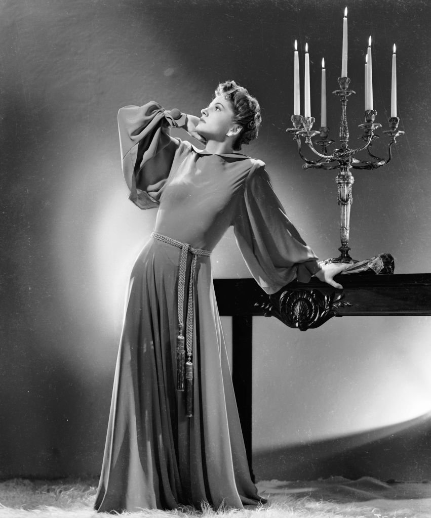 British-born actress Joan Fontaine strikes a theatrical pose in a floor-length belted gown circa 1941. | Source: Getty Images