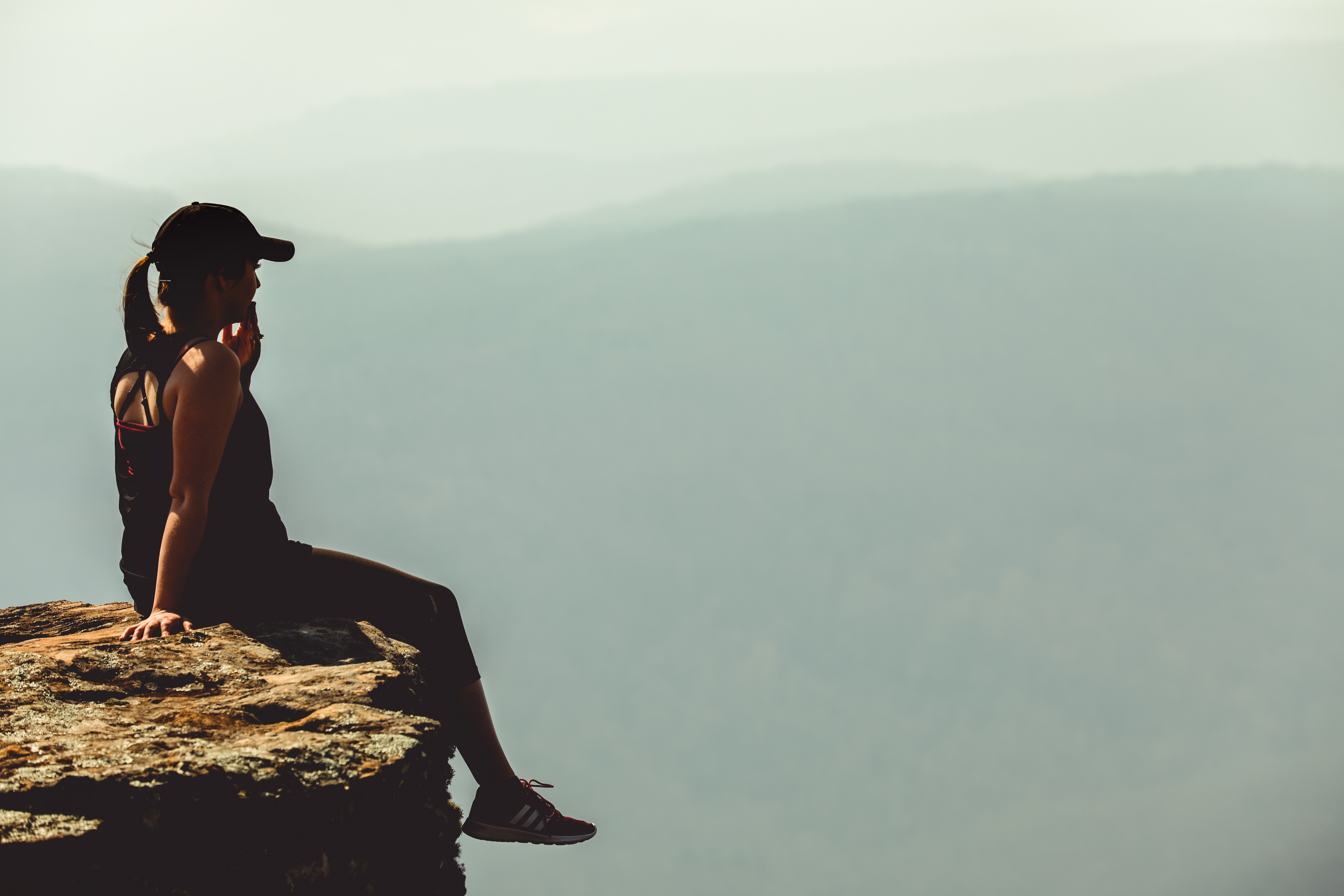A woman sitting on the edge of a cliff. | Source: Pexels