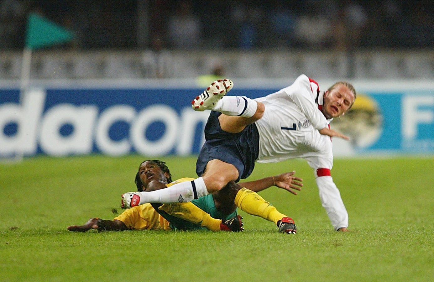 David Beckham tackled and upended by Thabang Molefe during a match between South Africa and England on May 22, 2003 in Durban, South Africa | Source: Getty Images