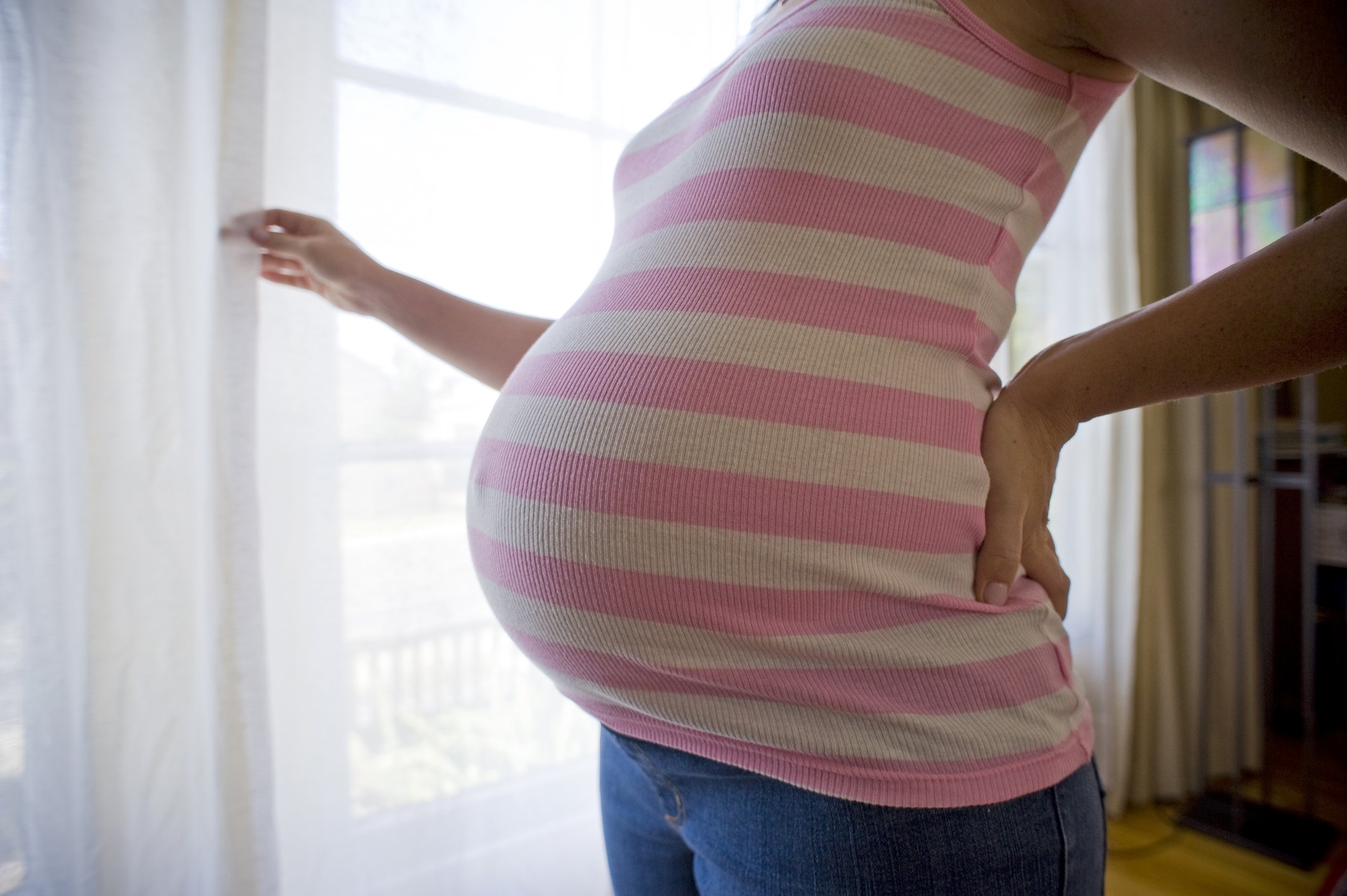 A pregnant woman by the window side. | Photo: Getty Images
