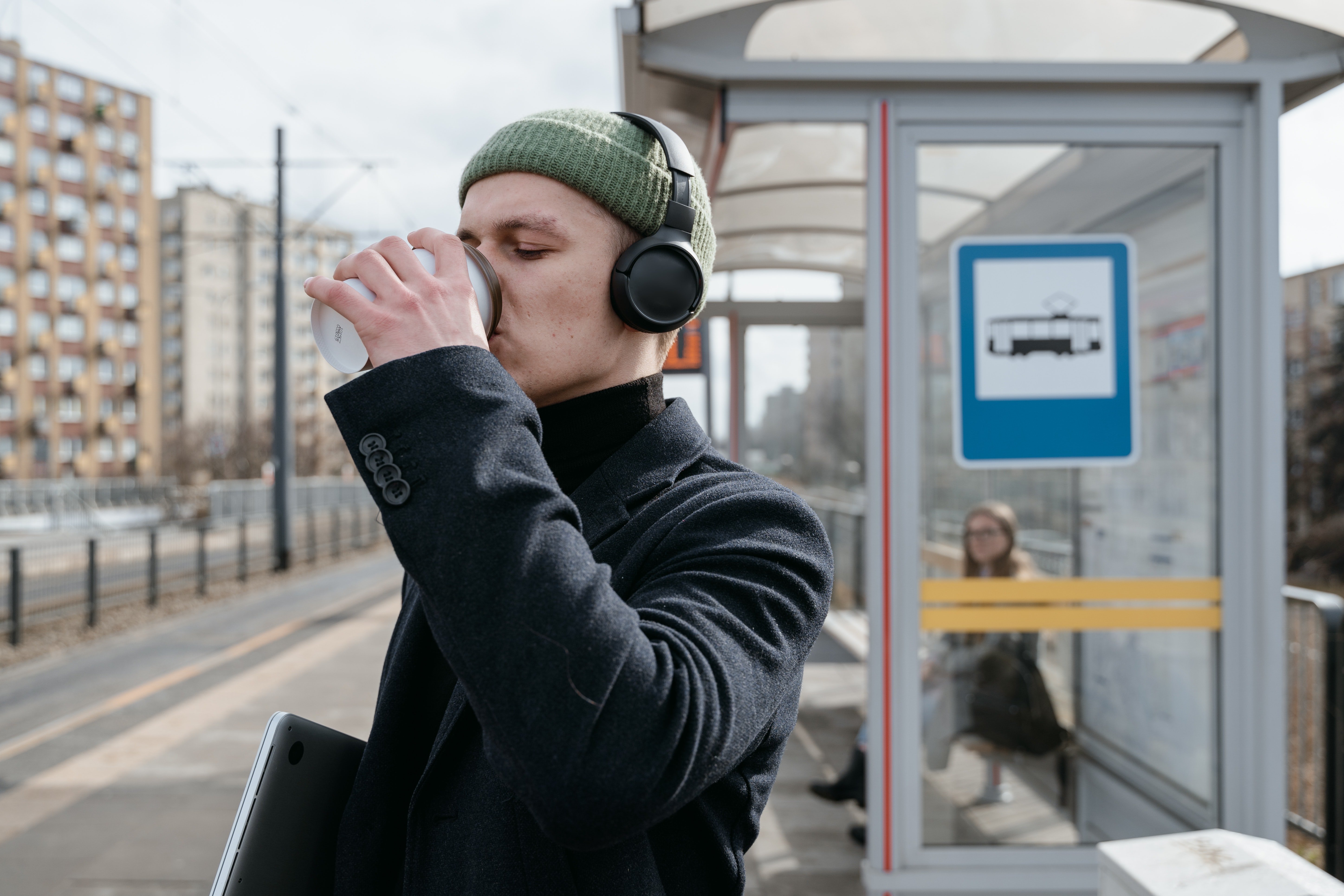 Un hombre toma un café, en la parada de autobuses. | Foto: Pexels