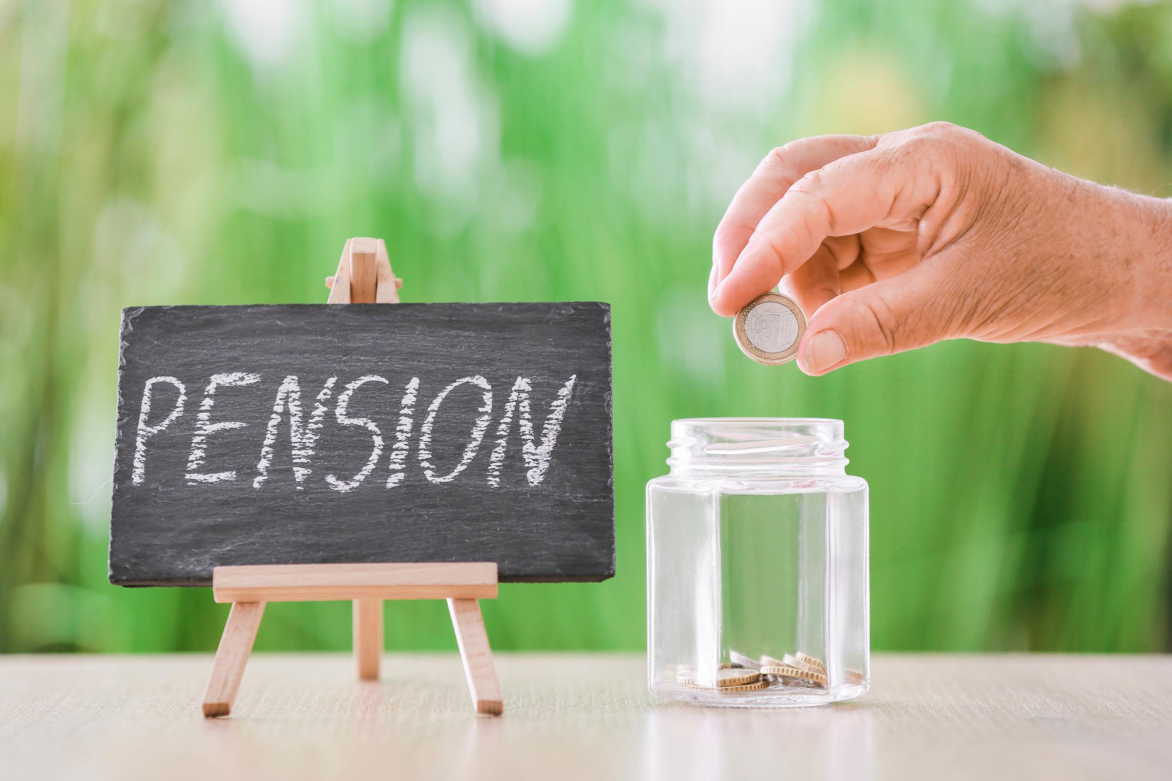 Hand of a senior person putting coins in a jar | Source: Shutterstock