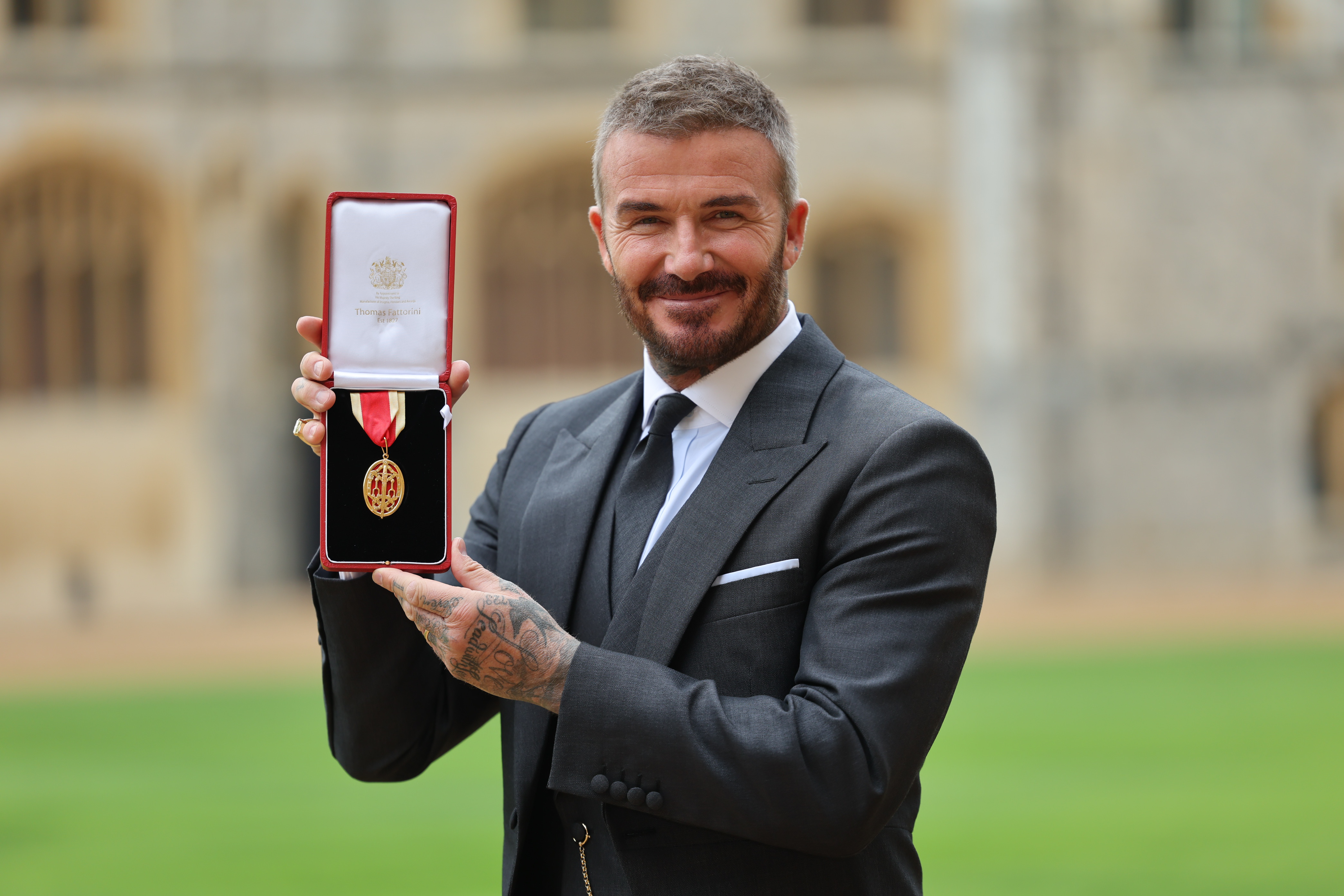 Sir David Beckham posing with his medal after receiving his knighthood for services to sport and charity at Windsor Castle on November 4, 2025, in England. | Source: Getty Images