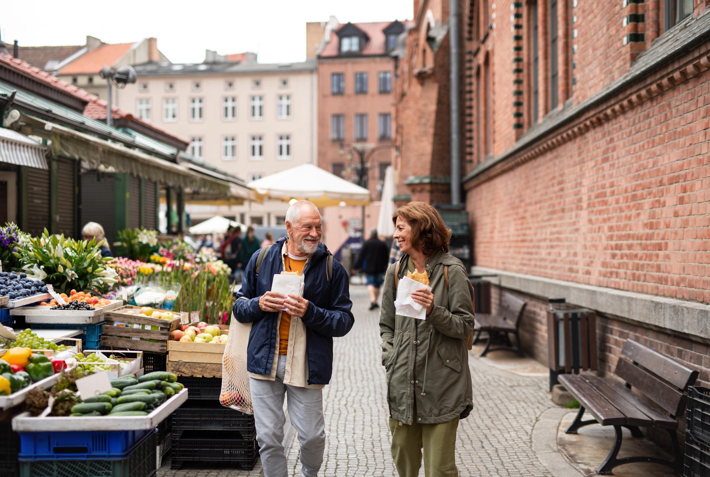 A couple of travelers strolling along an outdoor market | Source: Shutterstock