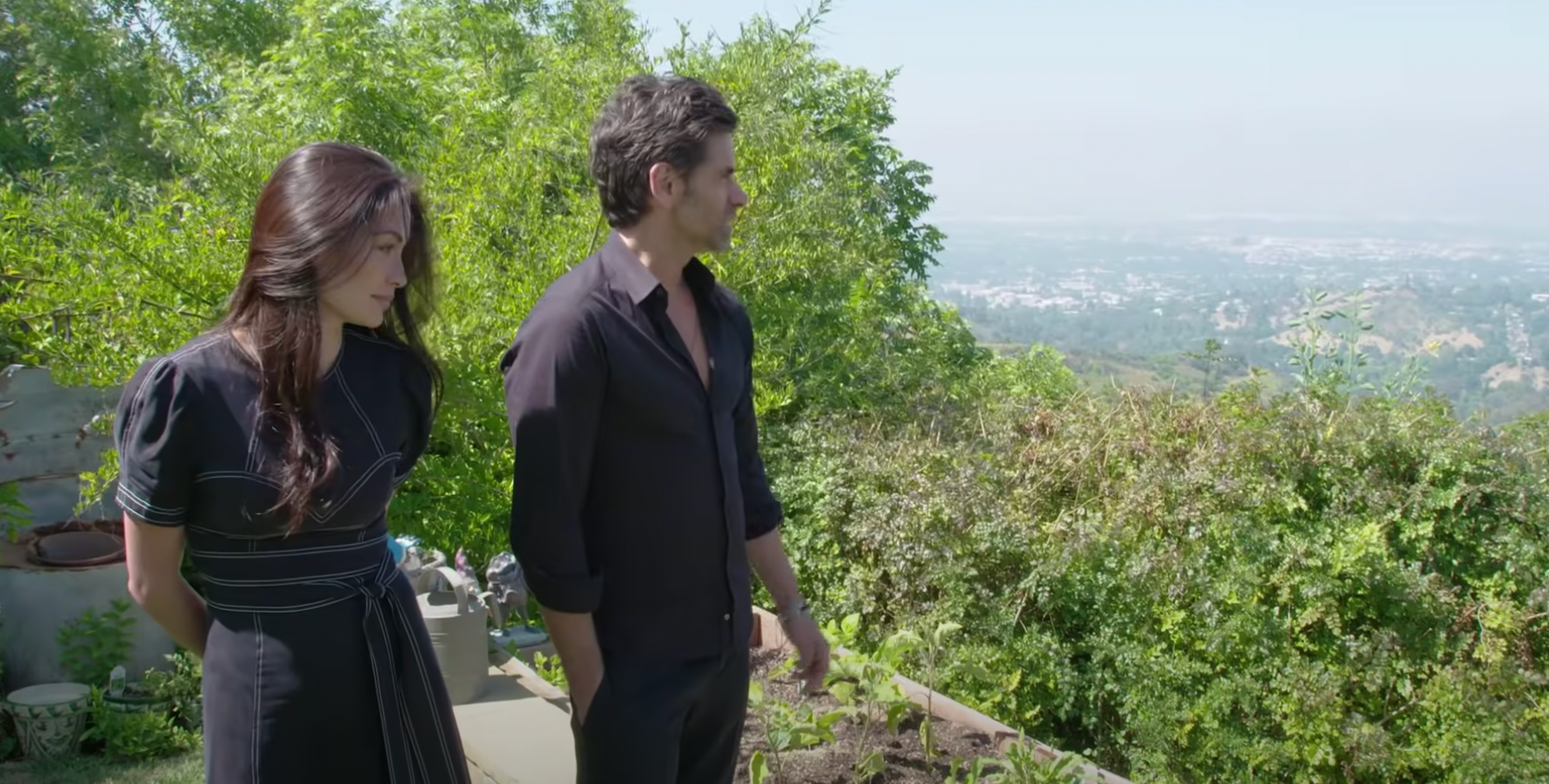 John Stamos and Caitlin McHugh pictured looking at views from their backyard in their former home in Los Angeles | Source: YouTube@ArchitecturalDigest