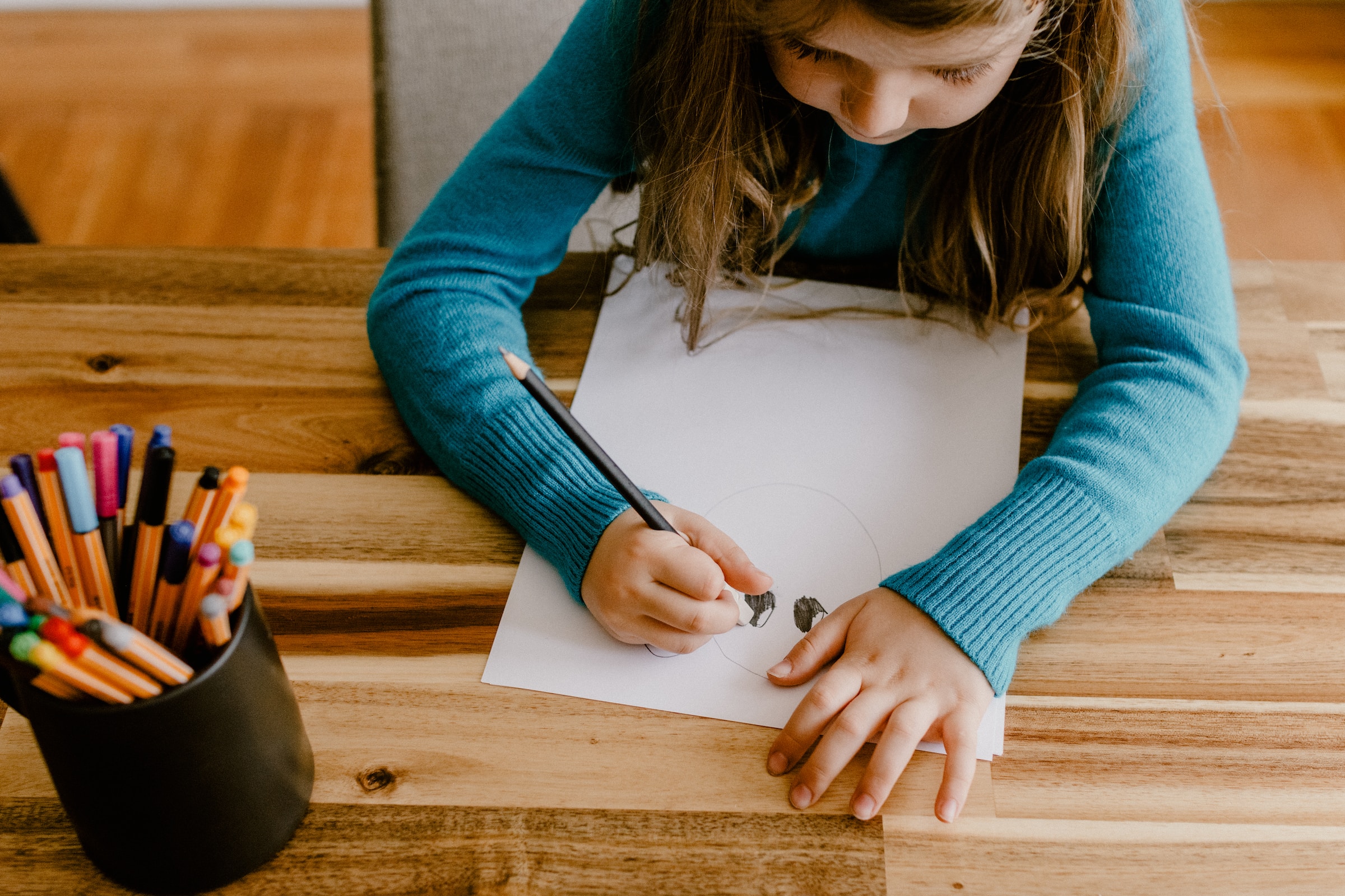A little girl sketching on a piece of paper | Source: Unsplash