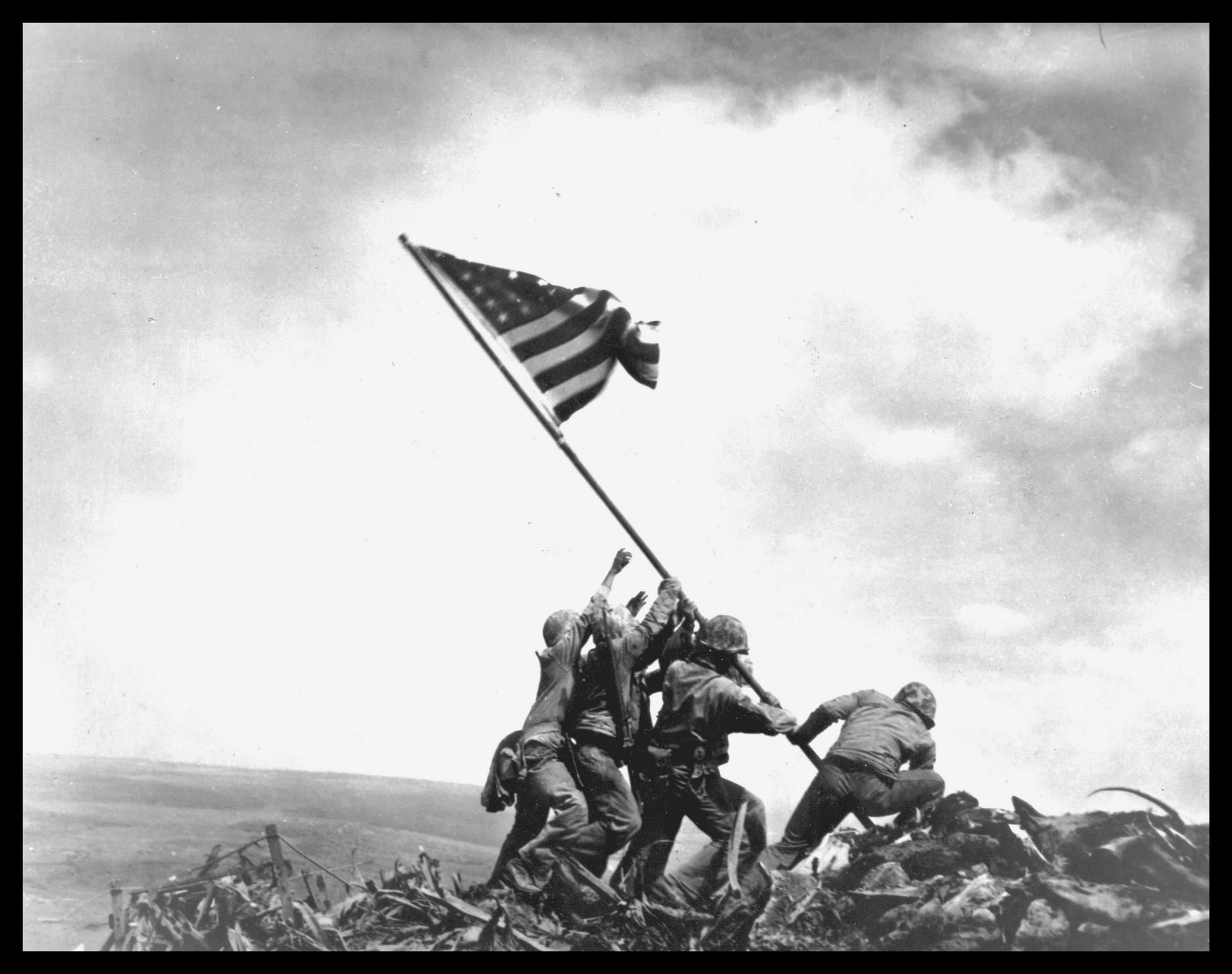 View of members of the United States Marine Corps 5th Division raising an American flag on Mount Suribachi during the Battle of Iwo Jima on February 23, 1945. | Source: Getty Images