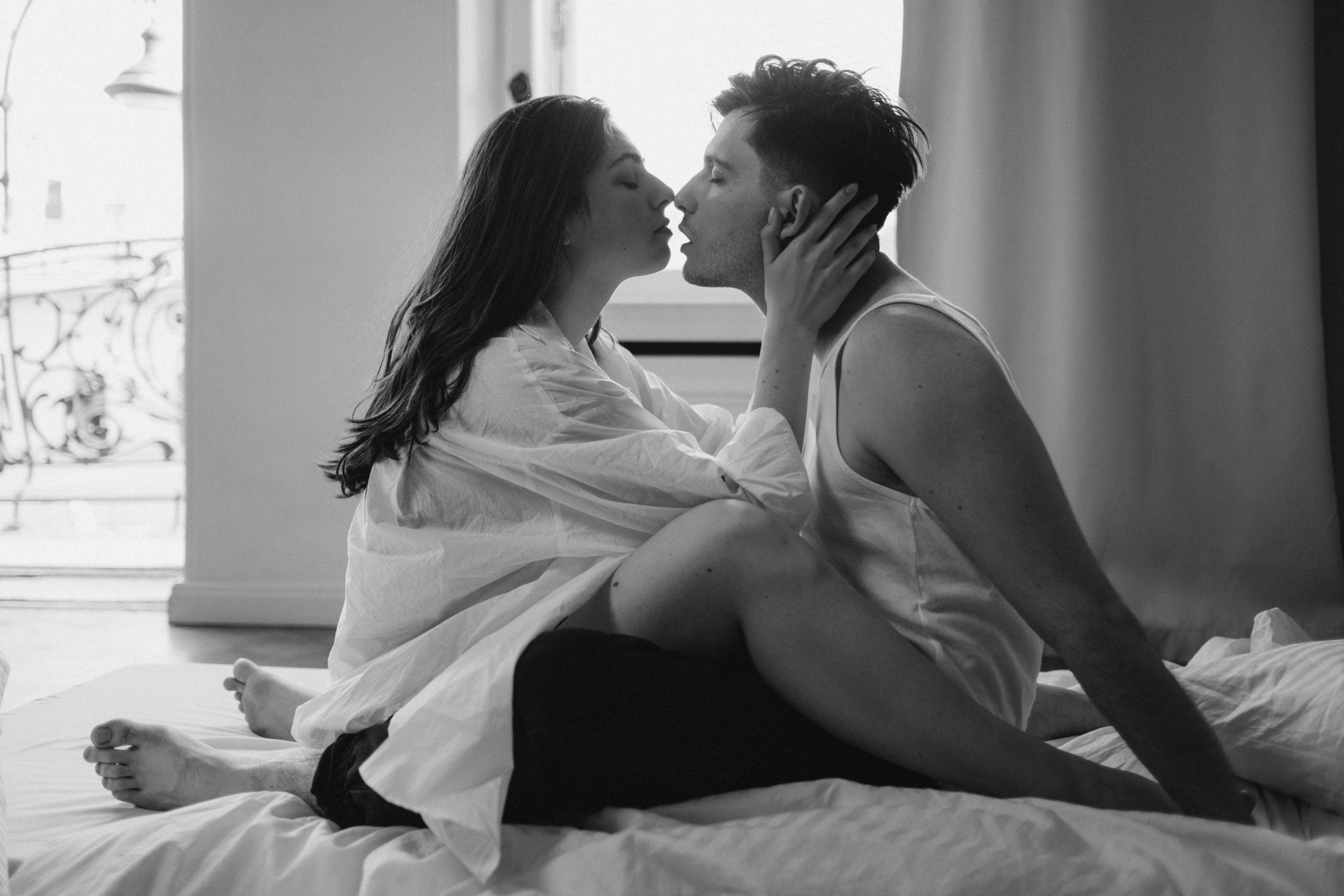 An intertwined couple about to share a kiss in bed | Source: Pexels