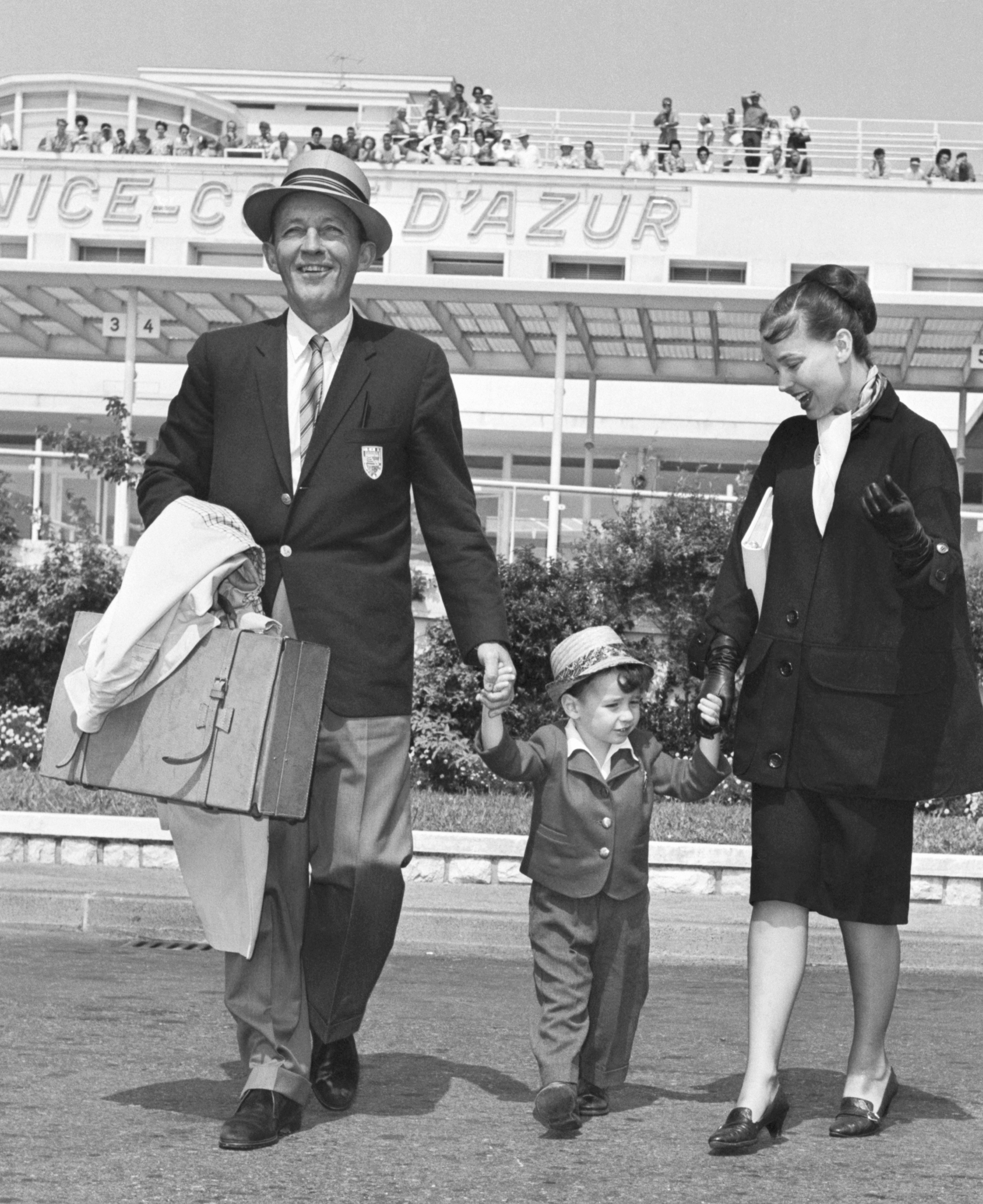 Bing Crosby, Kathryn, and their son Harry, 3, are shown after arriving from London, on August 25, 1961 | Source: Getty Images