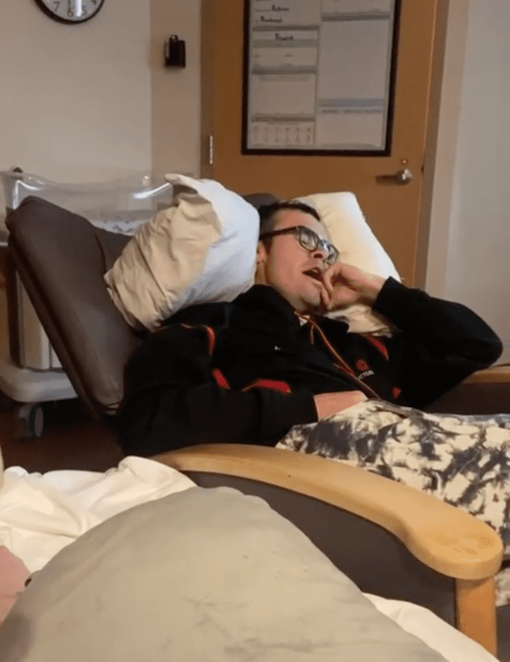 Father who walked to the hospital with his wife while she was in labor sits in the chair next to her bed | Photo: TikTok/kelskiller