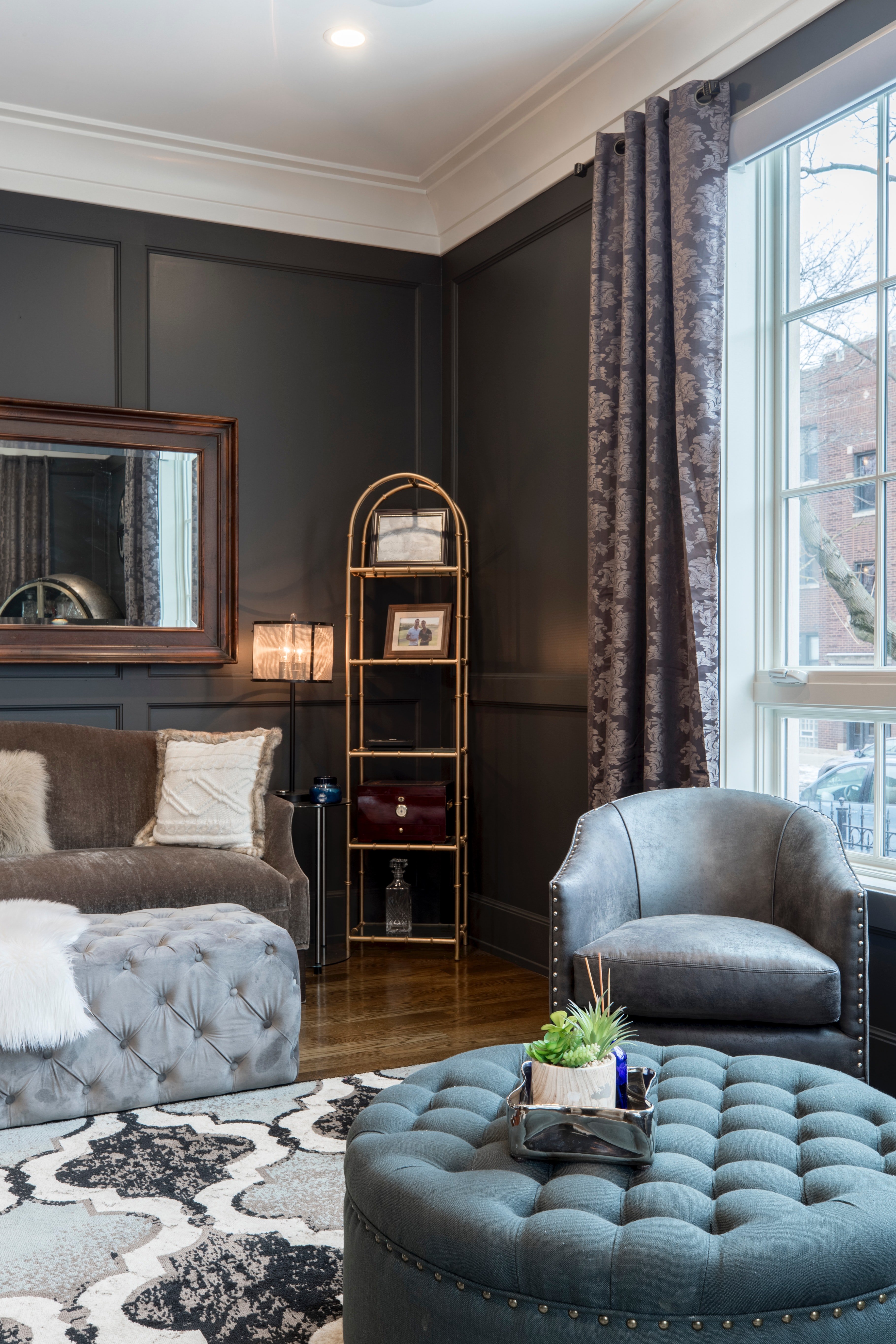 Pictured - An interior design of a house, a gray leather tub chair, a blue ottoman and dark gray walls | Source: Pexels   