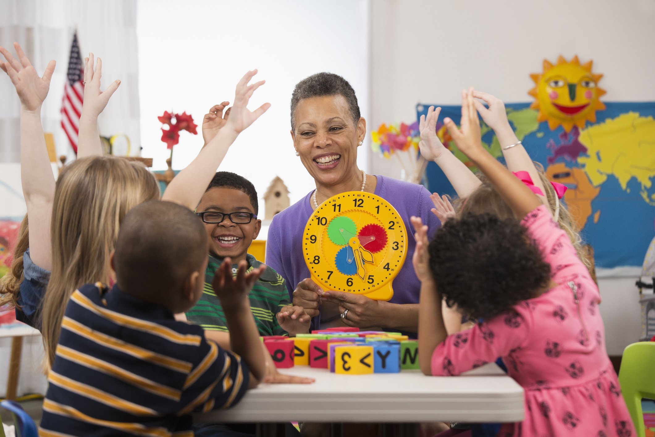 Kindergartenschüler und Lehrer lesen Uhr. I Quelle: Getty Images