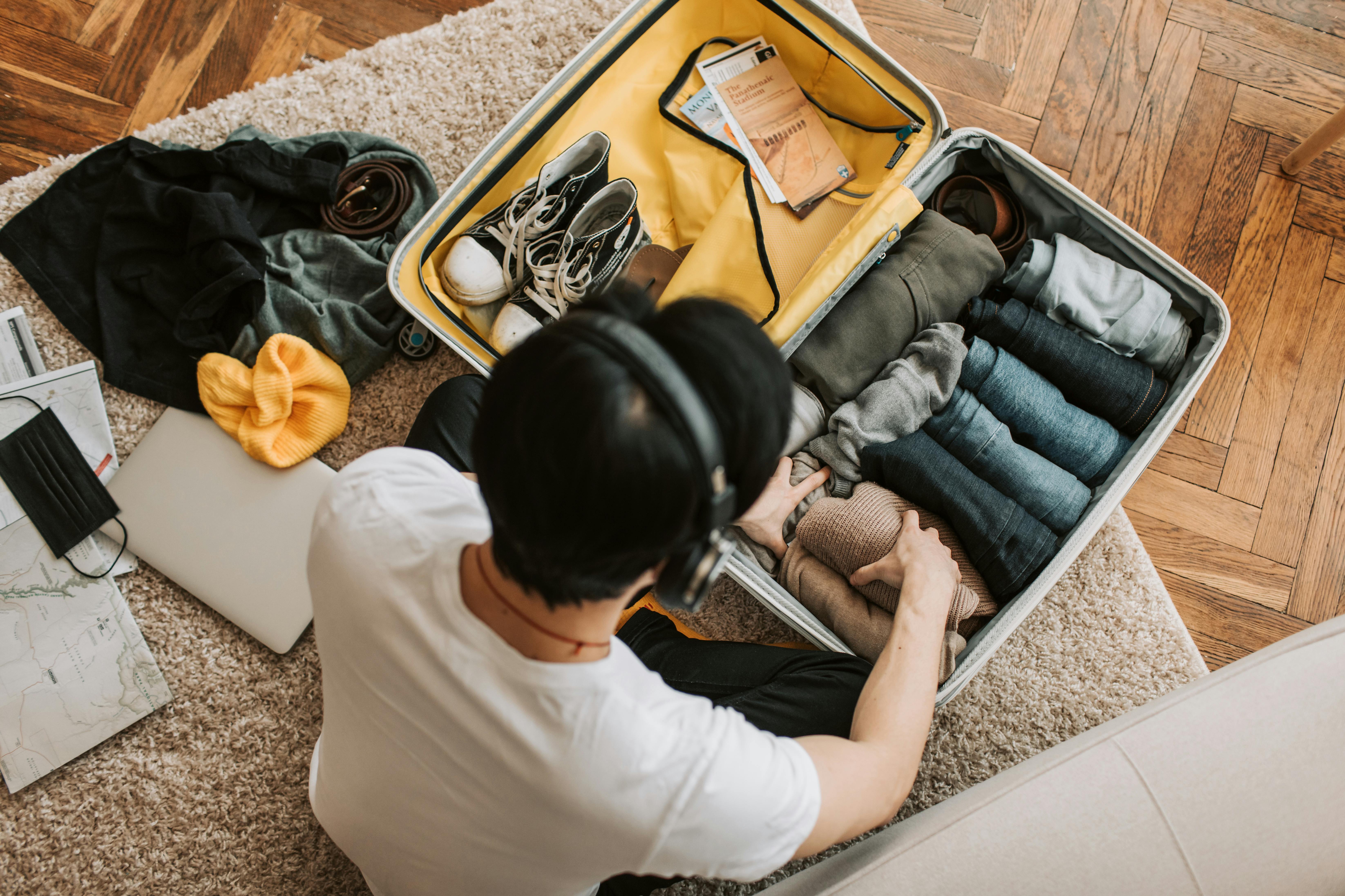 A man wearing headsets while packing his bag | Source: Pexels
