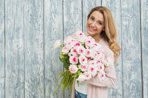 Rubia sosteniendo un ramo de rosas. │Foto: Freepik