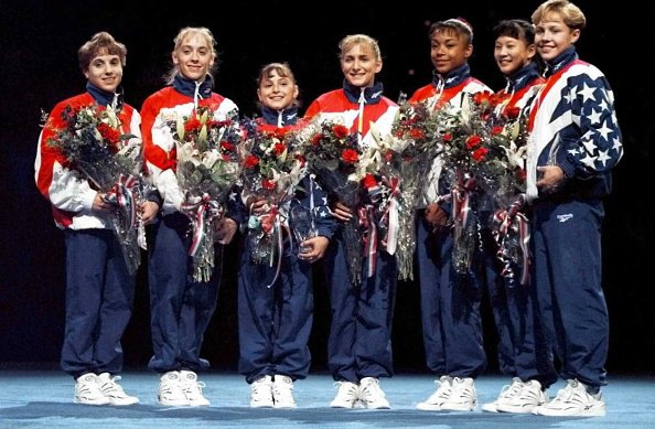 The 1996 US Women's Gymnastic's Olympic Team (L-R) Kerri Strug, Jaycie Phelps, Dominique Moceanu, Shannon Miller, Dominique Dawes, Amy Chow and Amanda Borden pose after the finals of the Women's Optionals at the 1996 US Olympic Gymnastic Team | Source: Getty Images