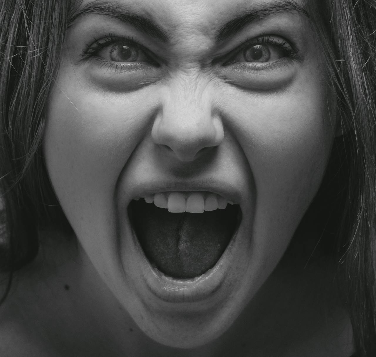 Grayscale portrait of an angry woman yelling | Source: Pexels
