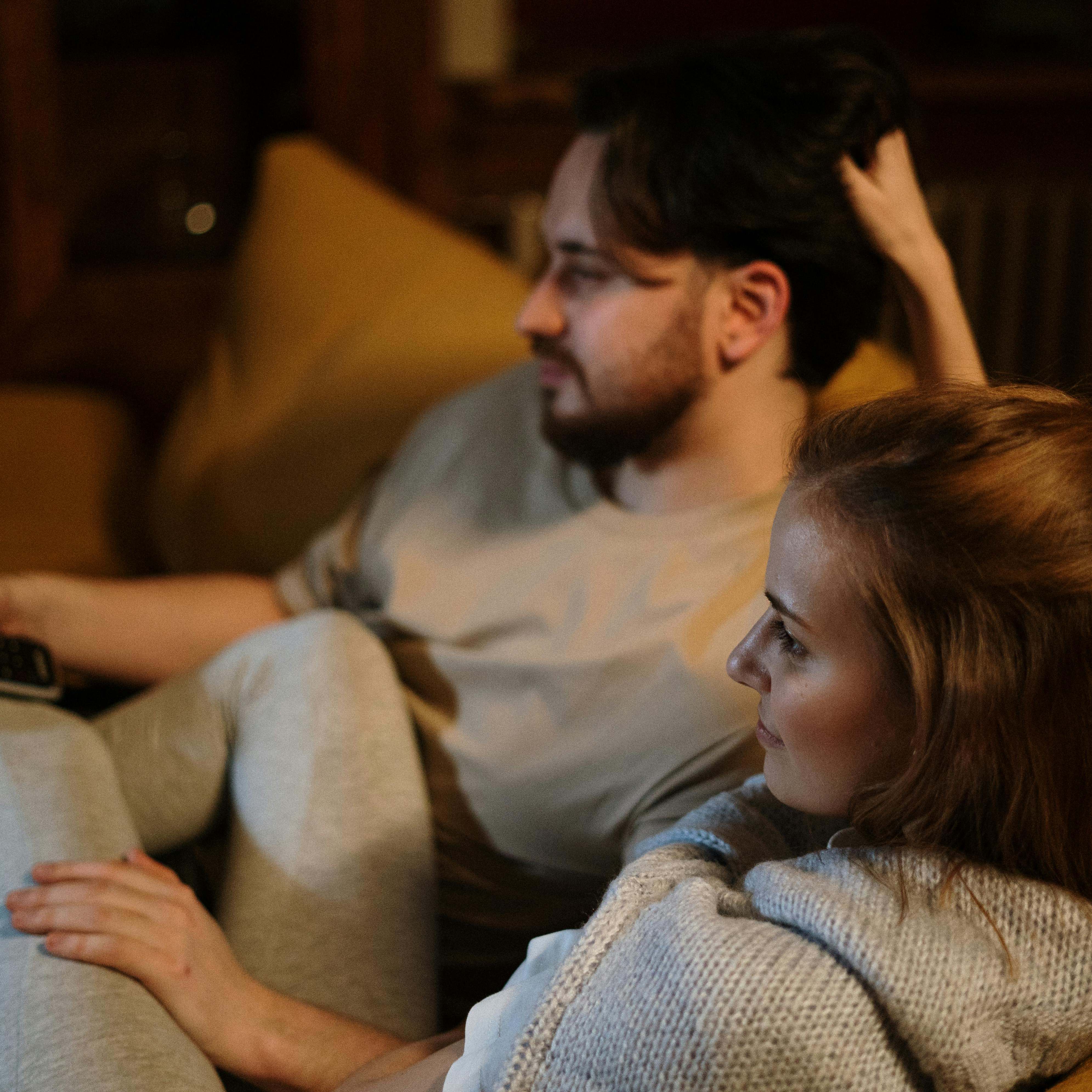 A couple relaxing on a sofa together | Source: Pexels