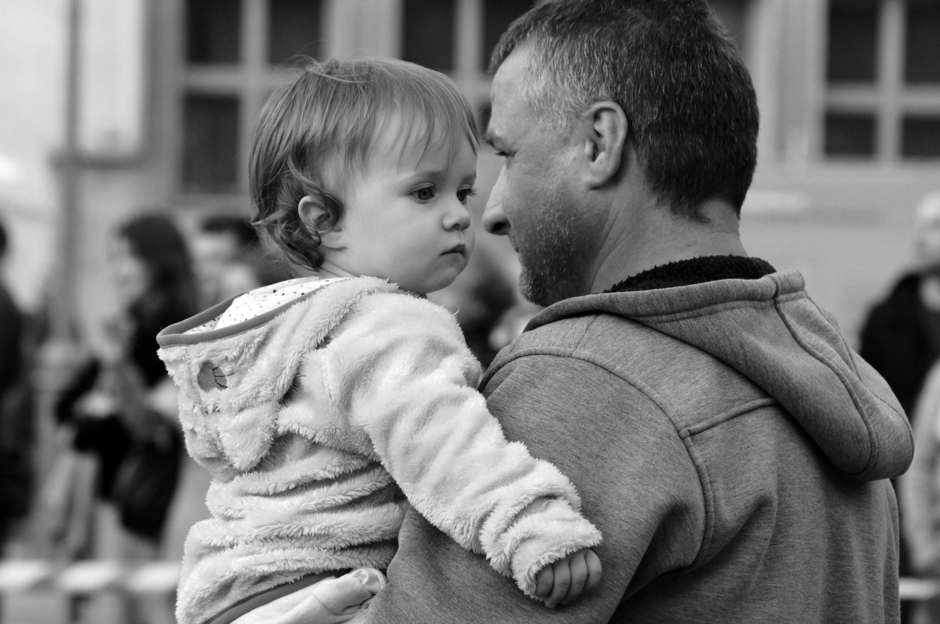 A man carrying a kid in his arms | Source: Pexels