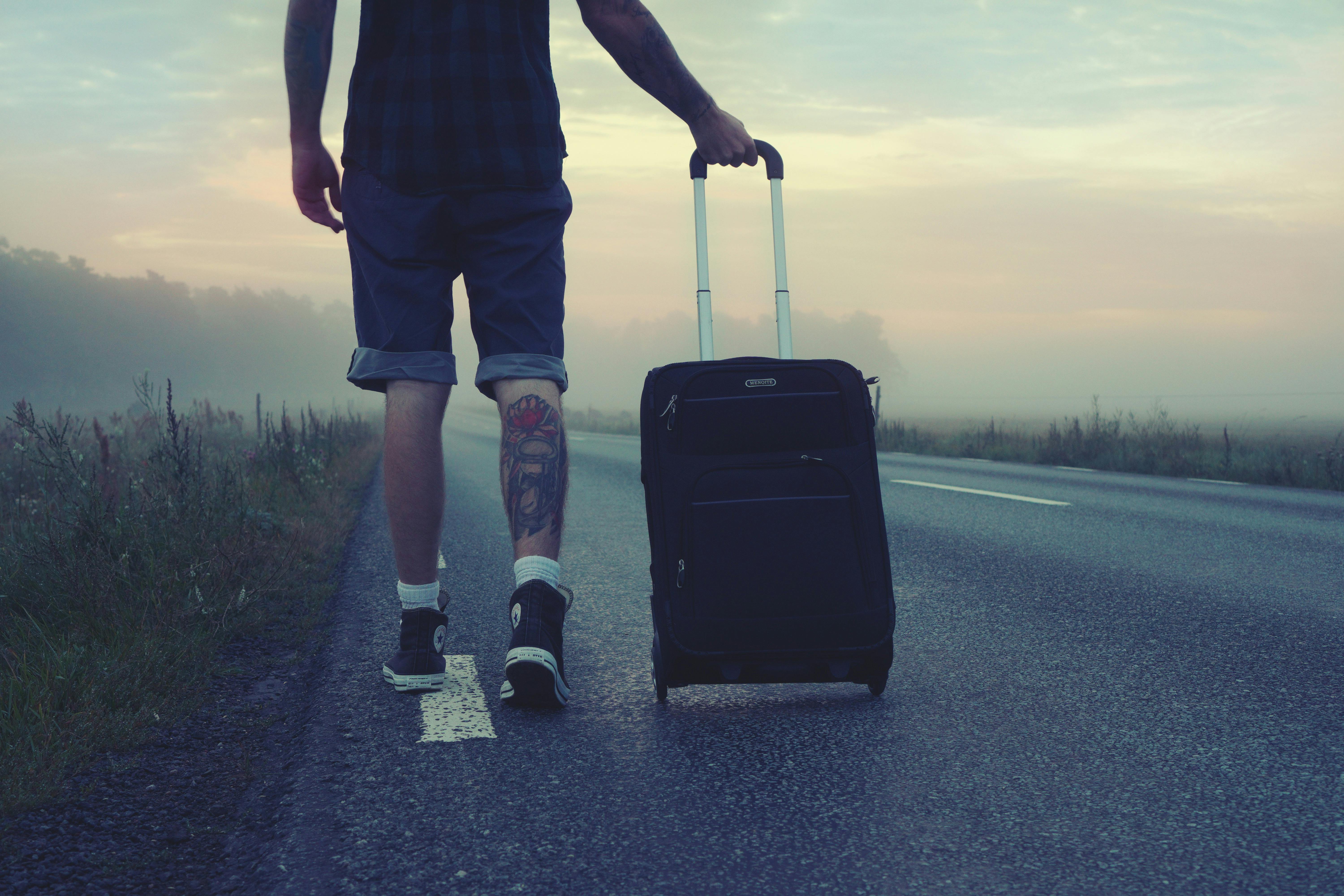 A man walking away with a suitcase | Source: Pexels