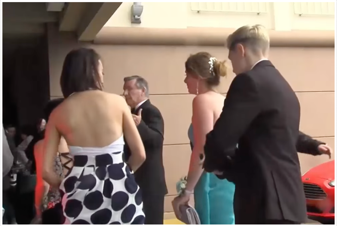 Aniya Wolf, who was barred from attending Bishop McDevitt's prom in a suit, with other people on May 9, 2016 | Source: YouTube/ABC News