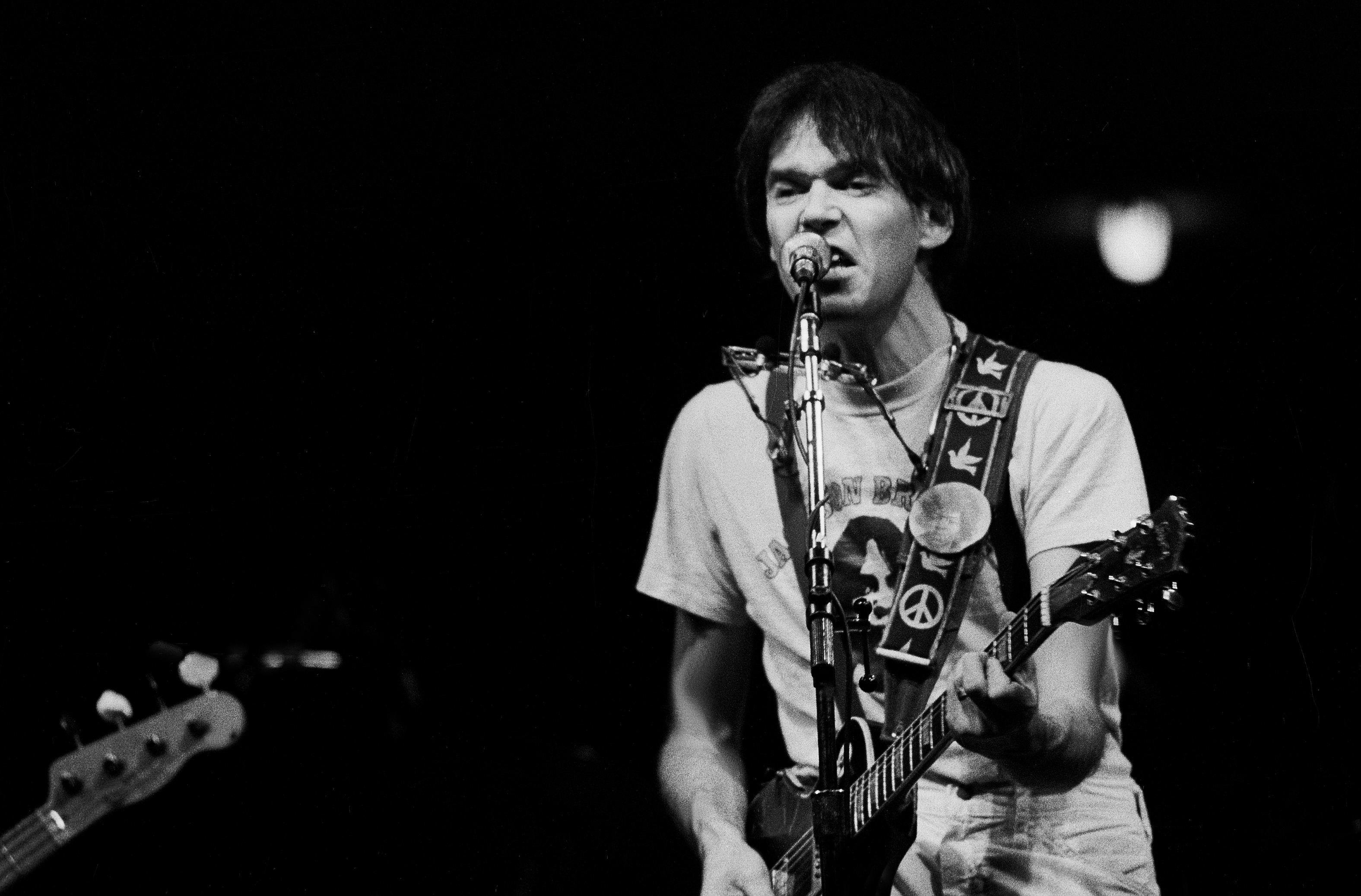 Neil Young plays guitar onstage at the Chicago Stadium, in 1978. | Source: Getty Images