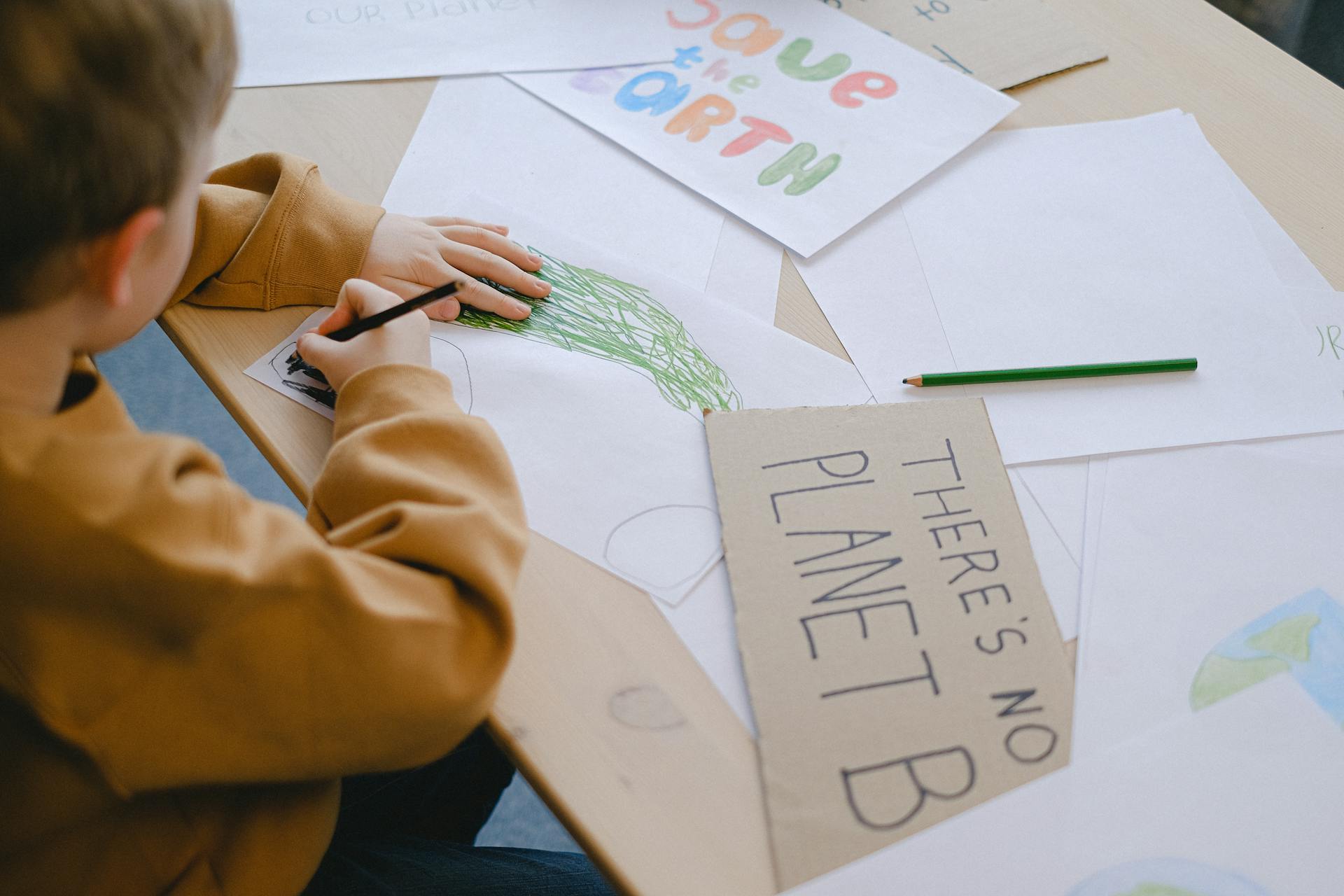 A little boy drawing at a desk | Source: Pexels