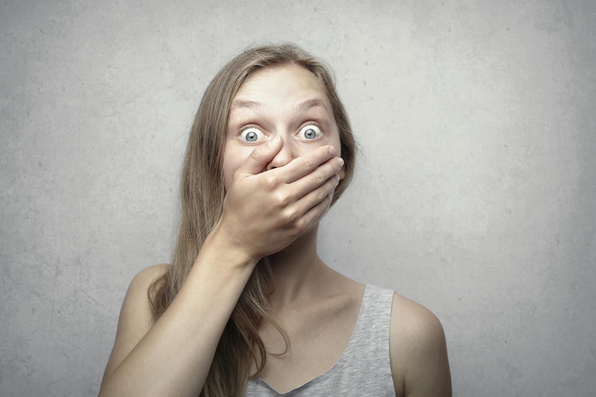 A shocked woman covering her mouth with her hand | Source: Pexels