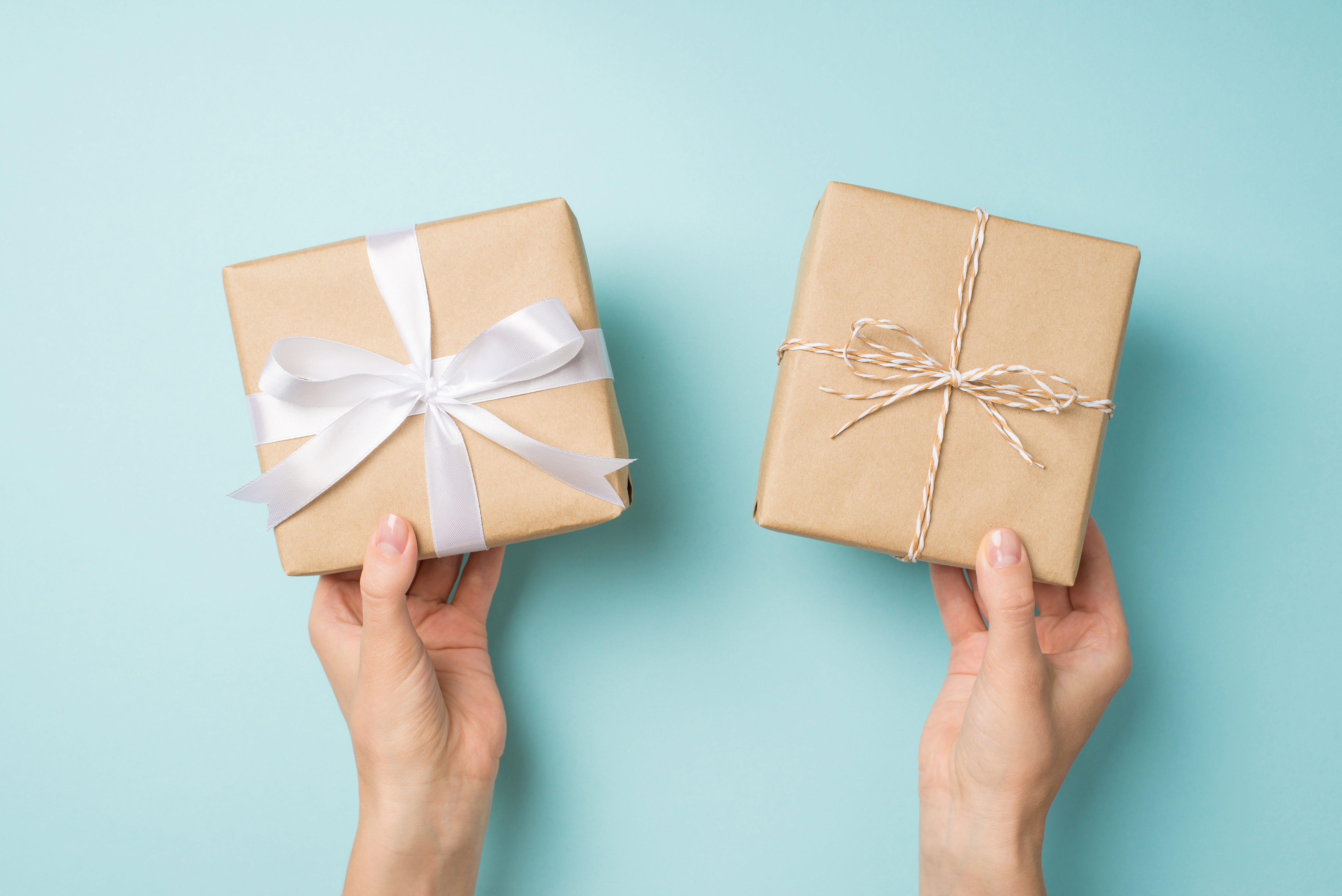 A person holding two gift boxes| Source: Shutterstock