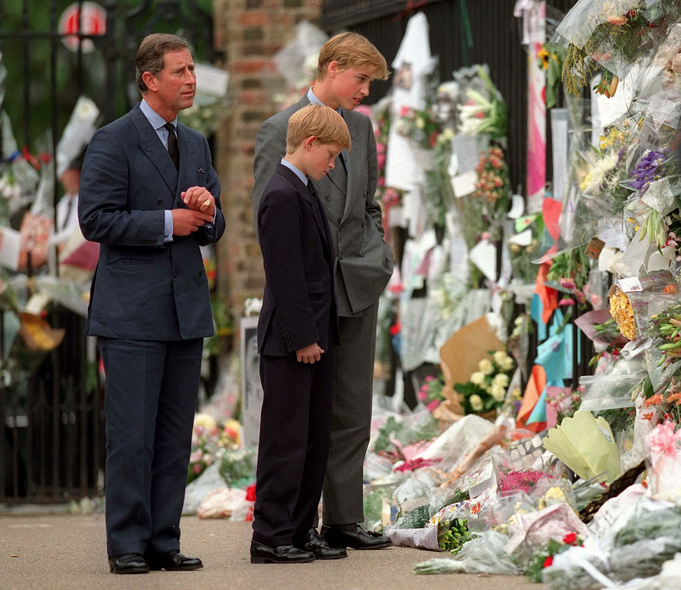 Prinz Charles, Prinz William und Prinz Harry sehen sich die Blumen zum Gedenken an Diana, Prinzessin von Wales, vor dem Kensington Palace am 5. September 1997 in London, England, an: Getty Images