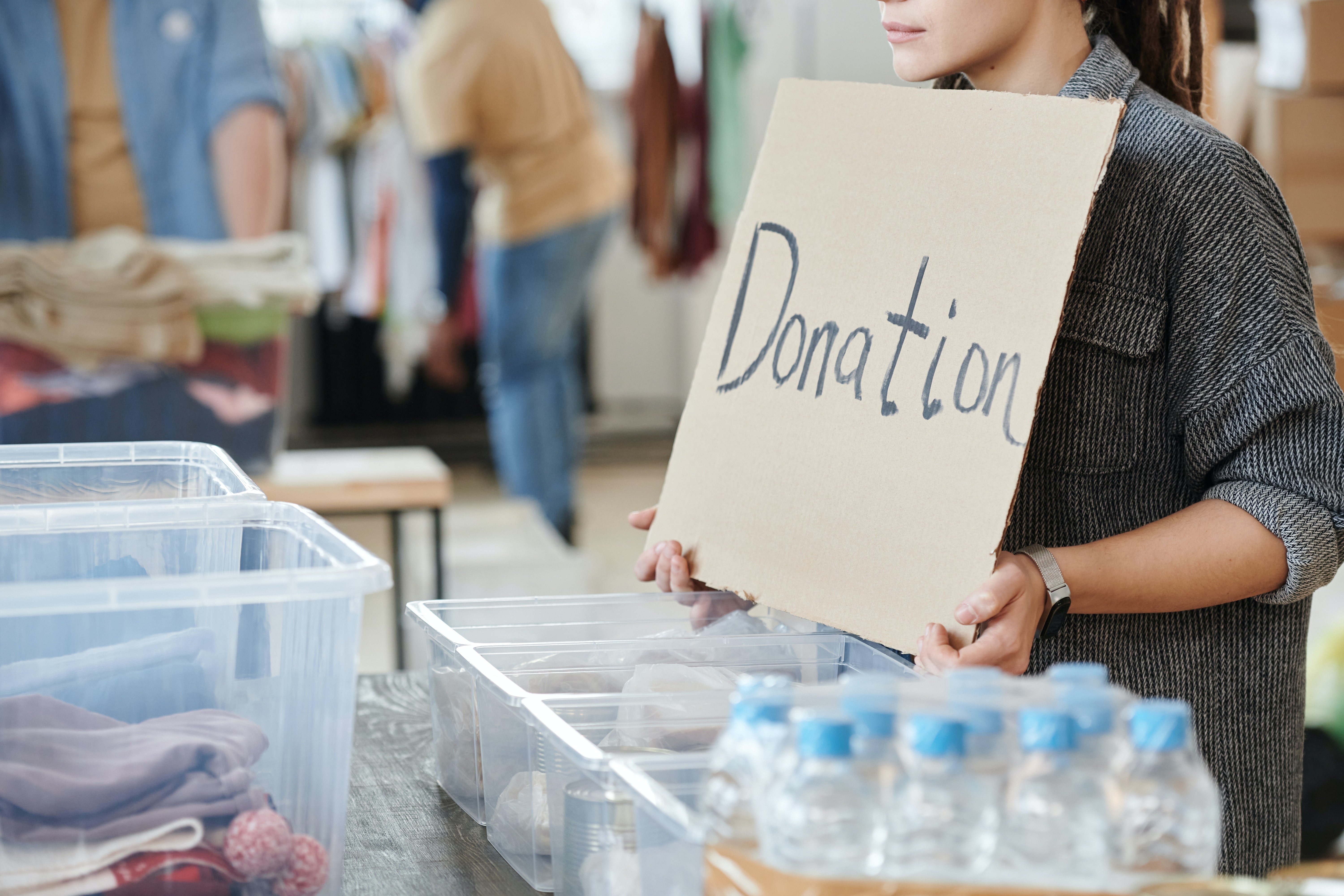 A woman holding a "donations" sign. | Photo: Pexels