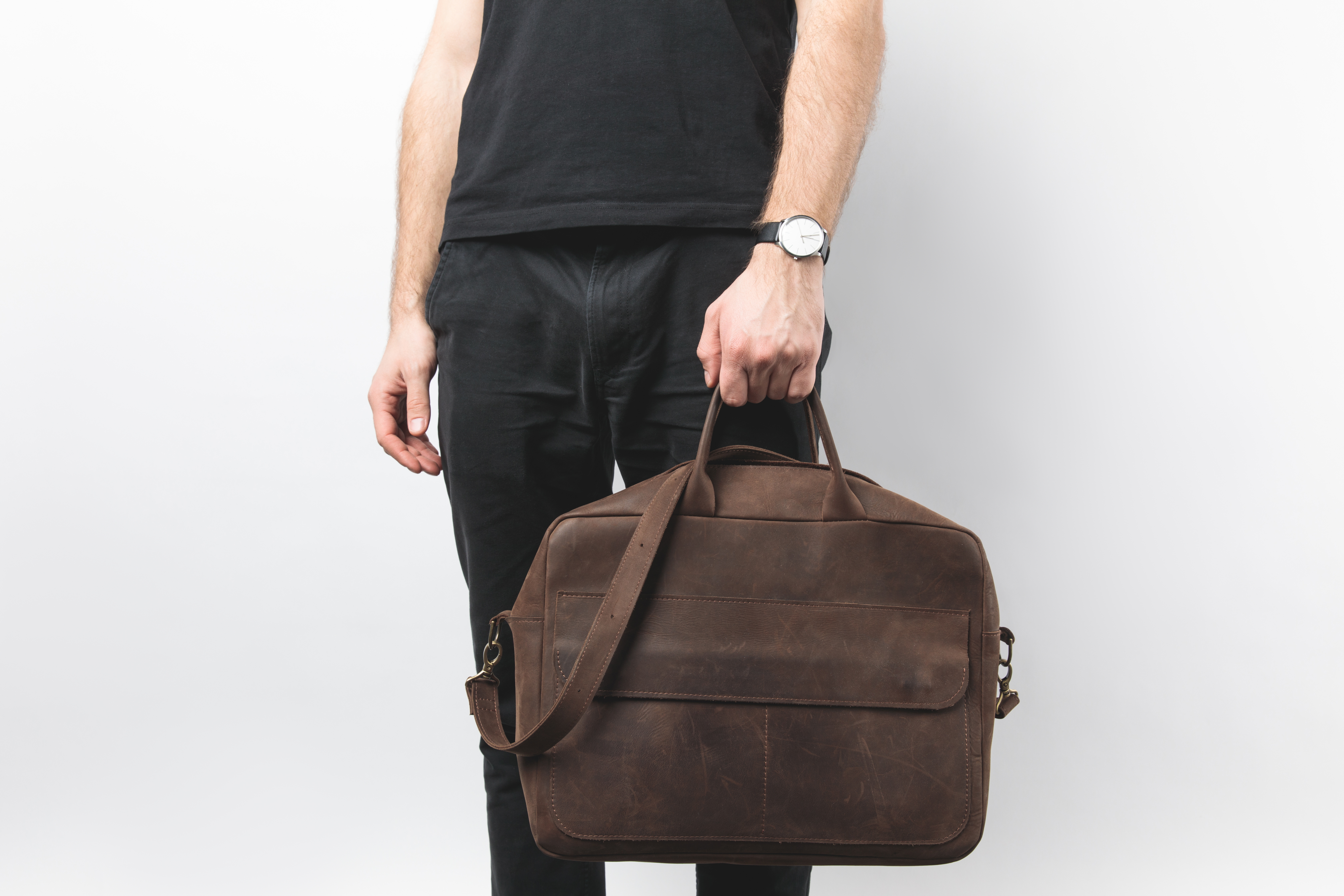 Partial view of man holding leather bag | Source: Shutterstock