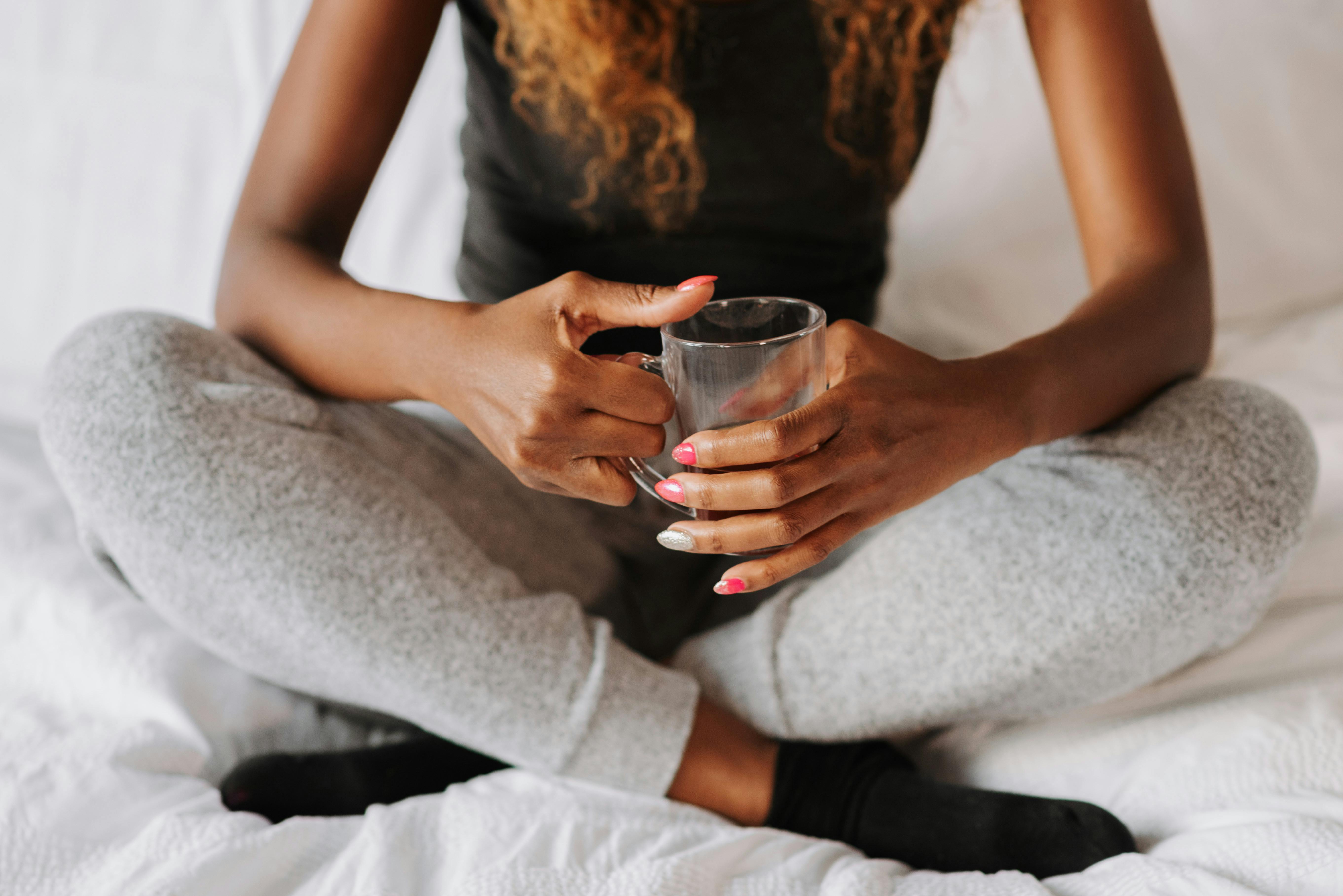 A woman with a cup in her bedroom | Source: Pexels