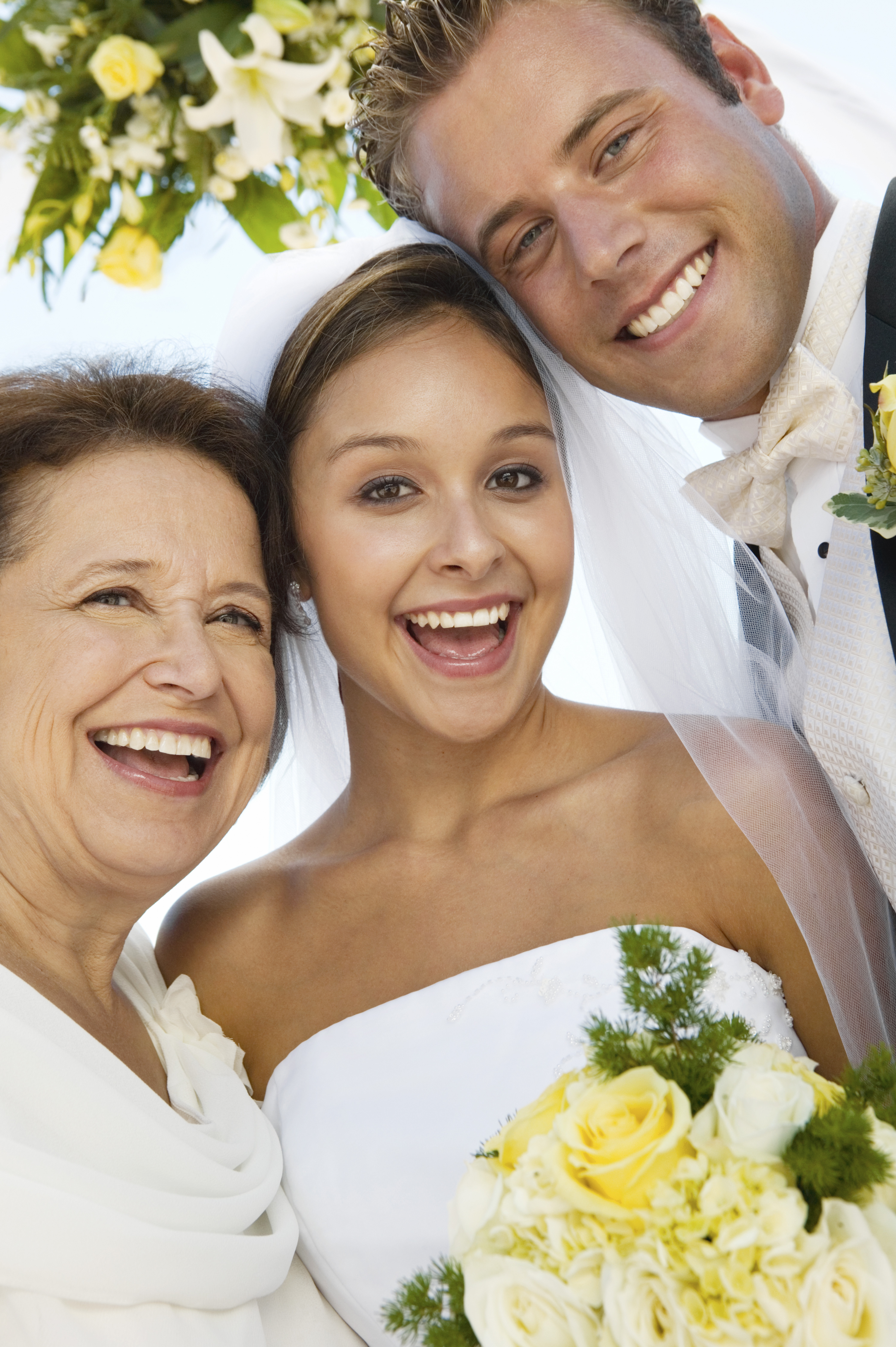 A bride and groom with their mom on their wedding day | Source: Shutterstock