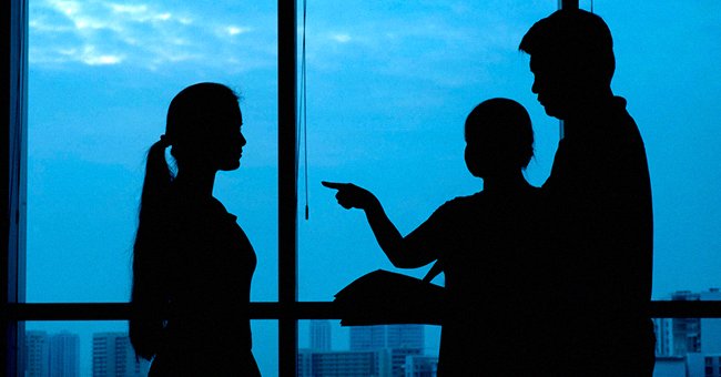 Silhouette of three people, one of them pointing a finger | Source: Shutterstock