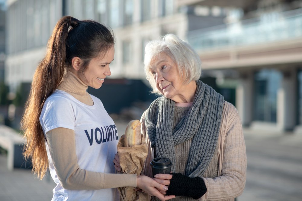 Mujer junto a una anciana con comestibles en sus manos. | Foto: Shutterstock