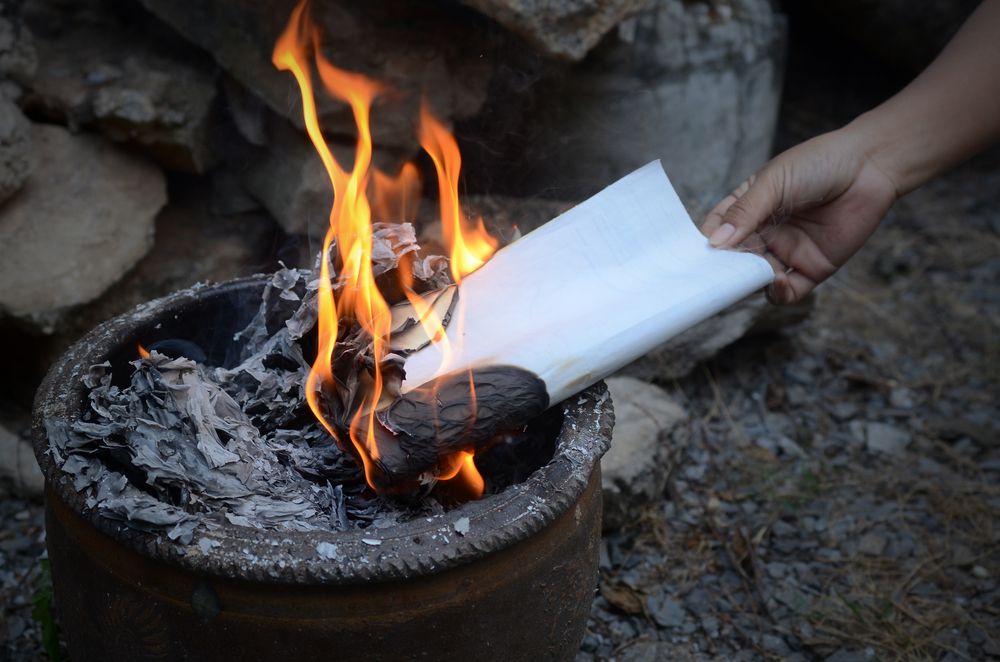 A letter being thrown to the fire. | Source: Shutterstock