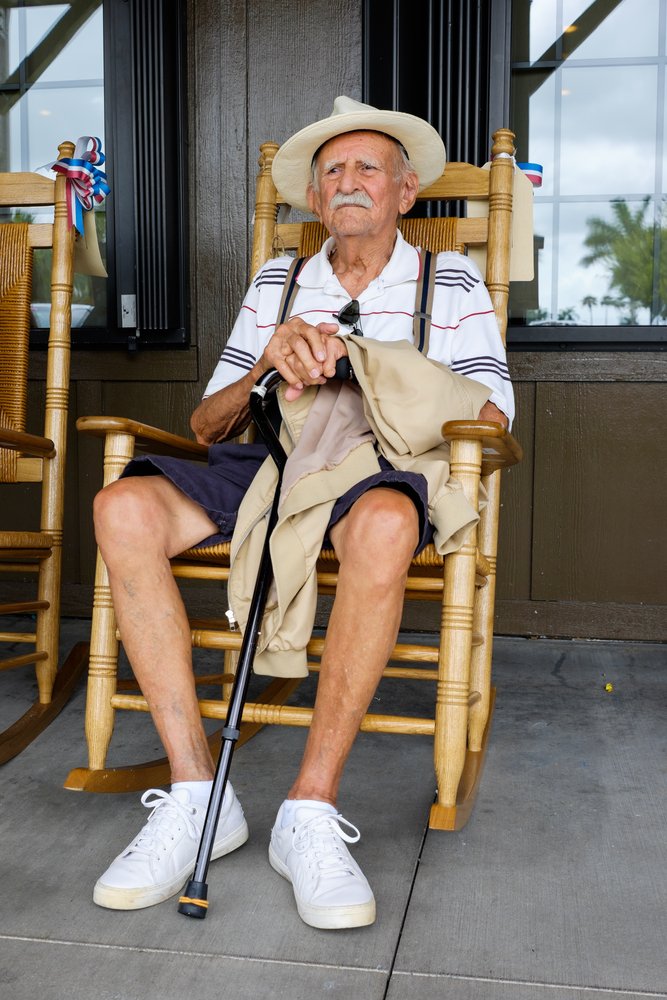 An elderly man sitting on a rocking chair. | Photo: Shutterstock.