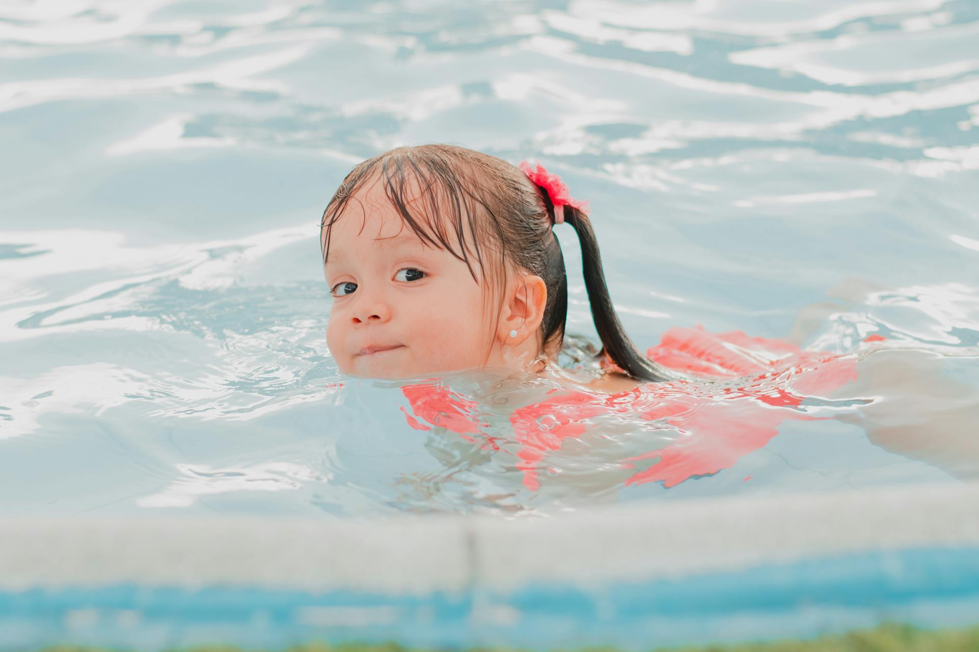 A little girl in a swimming pool | Source: Unsplash