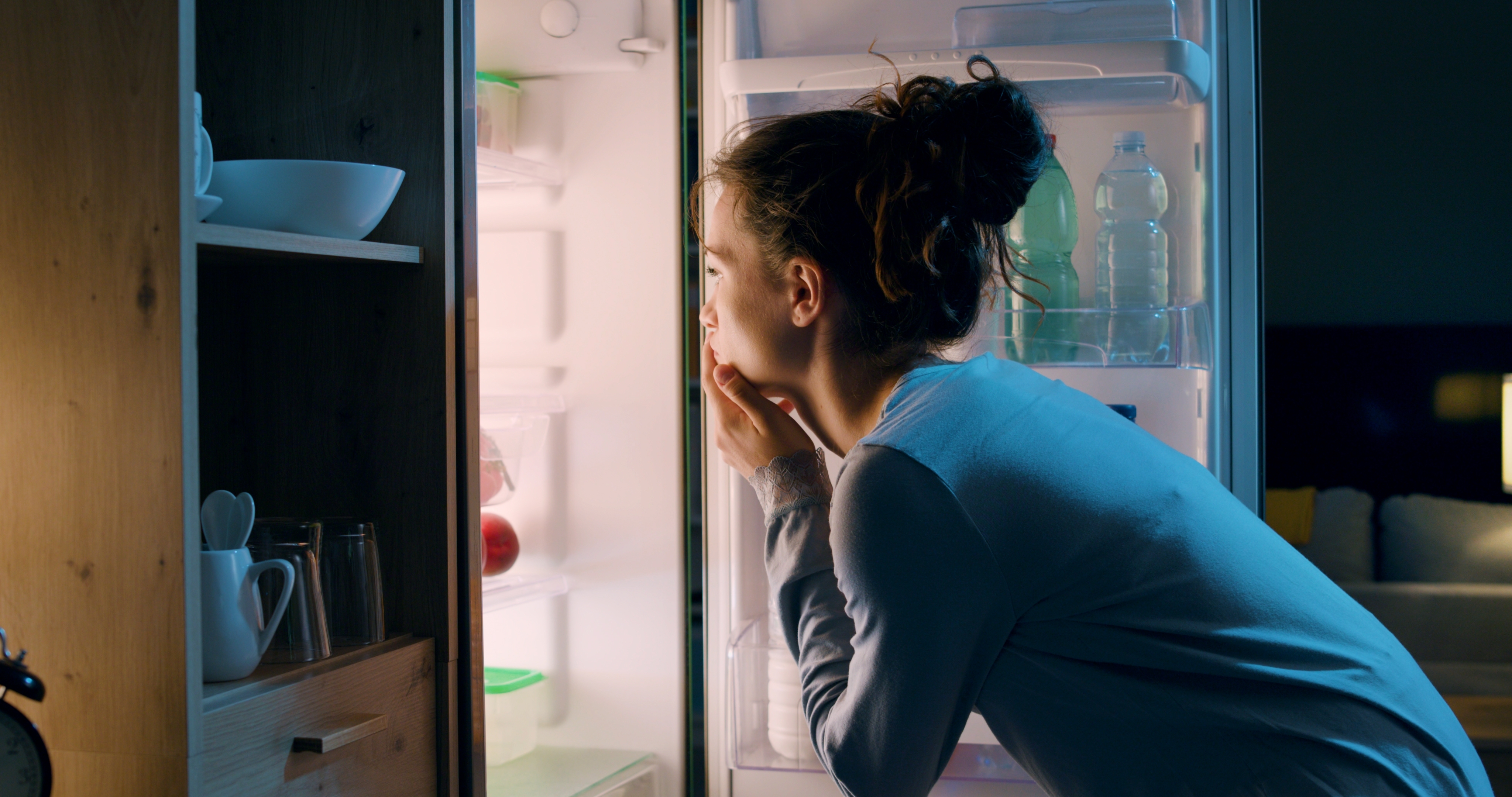 Woman looking in the fridge | Source: Shutterstock